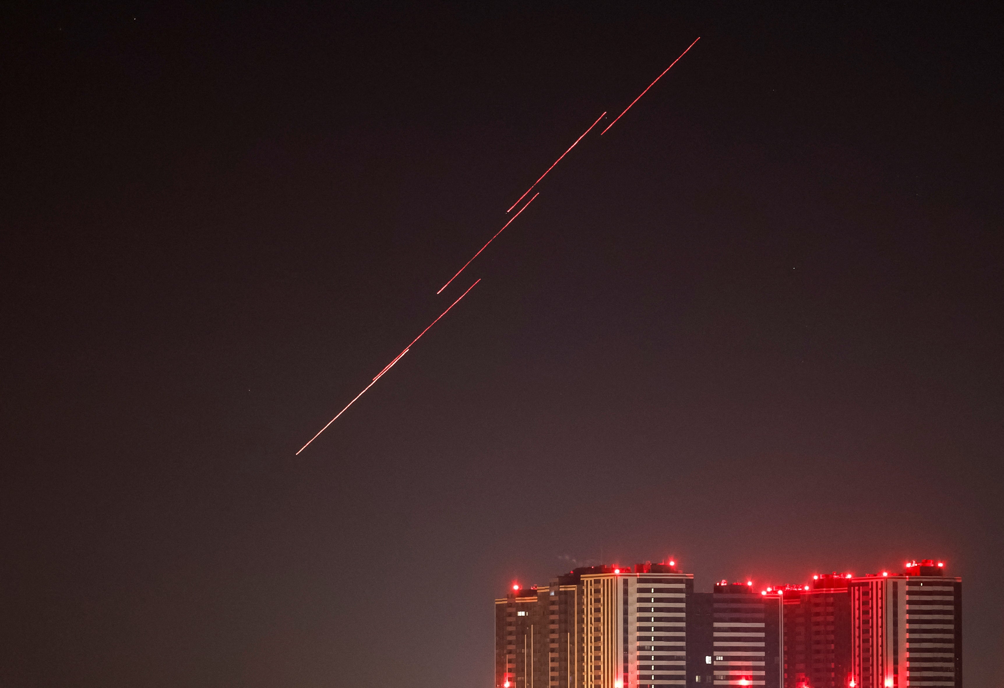 Tracers are seen in the night sky as Ukrainian servicemen fire at the drone during a Russian drone strike