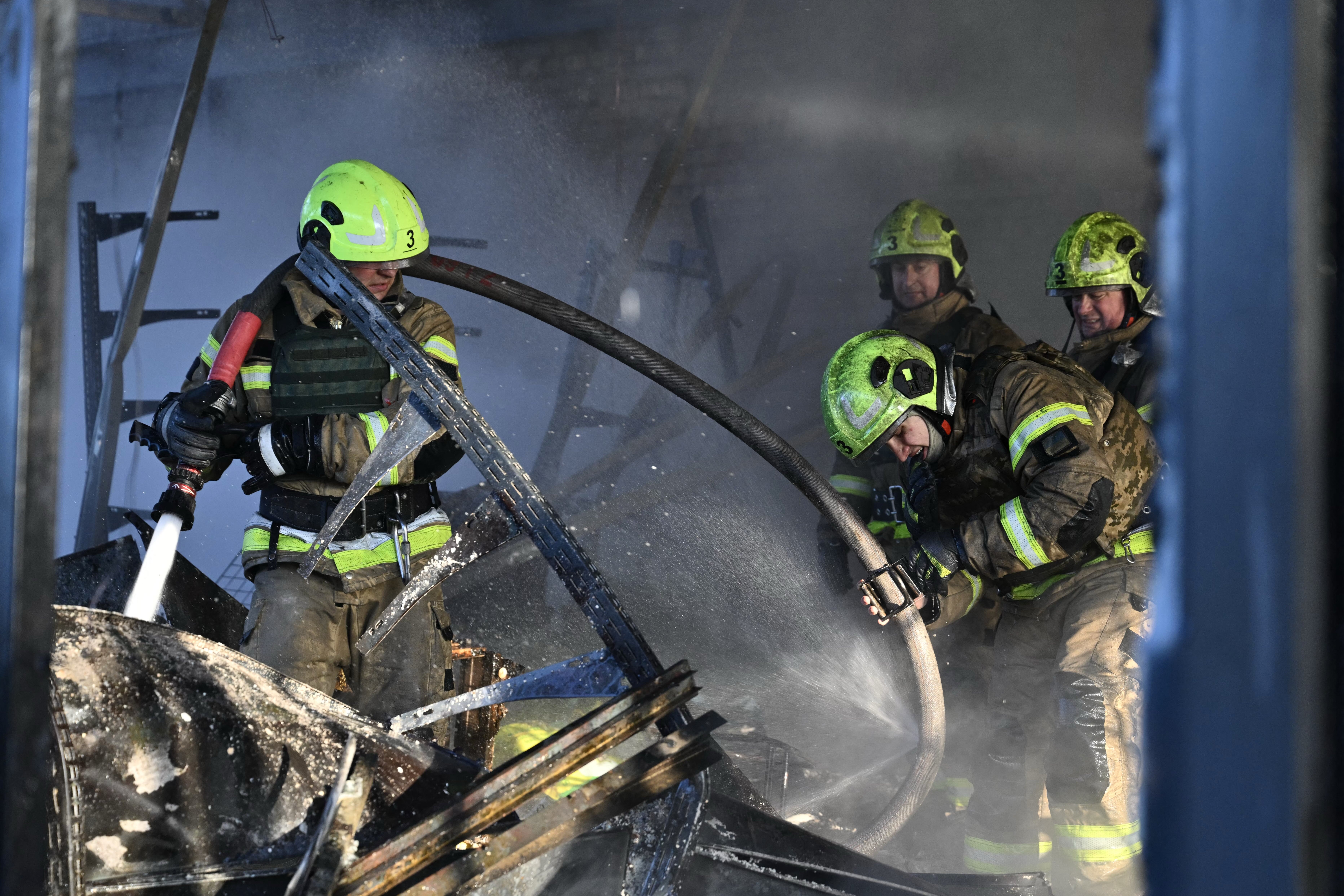 Ukrainian rescuers work to extinguish a fire in a building following a drone attack in Kyiv