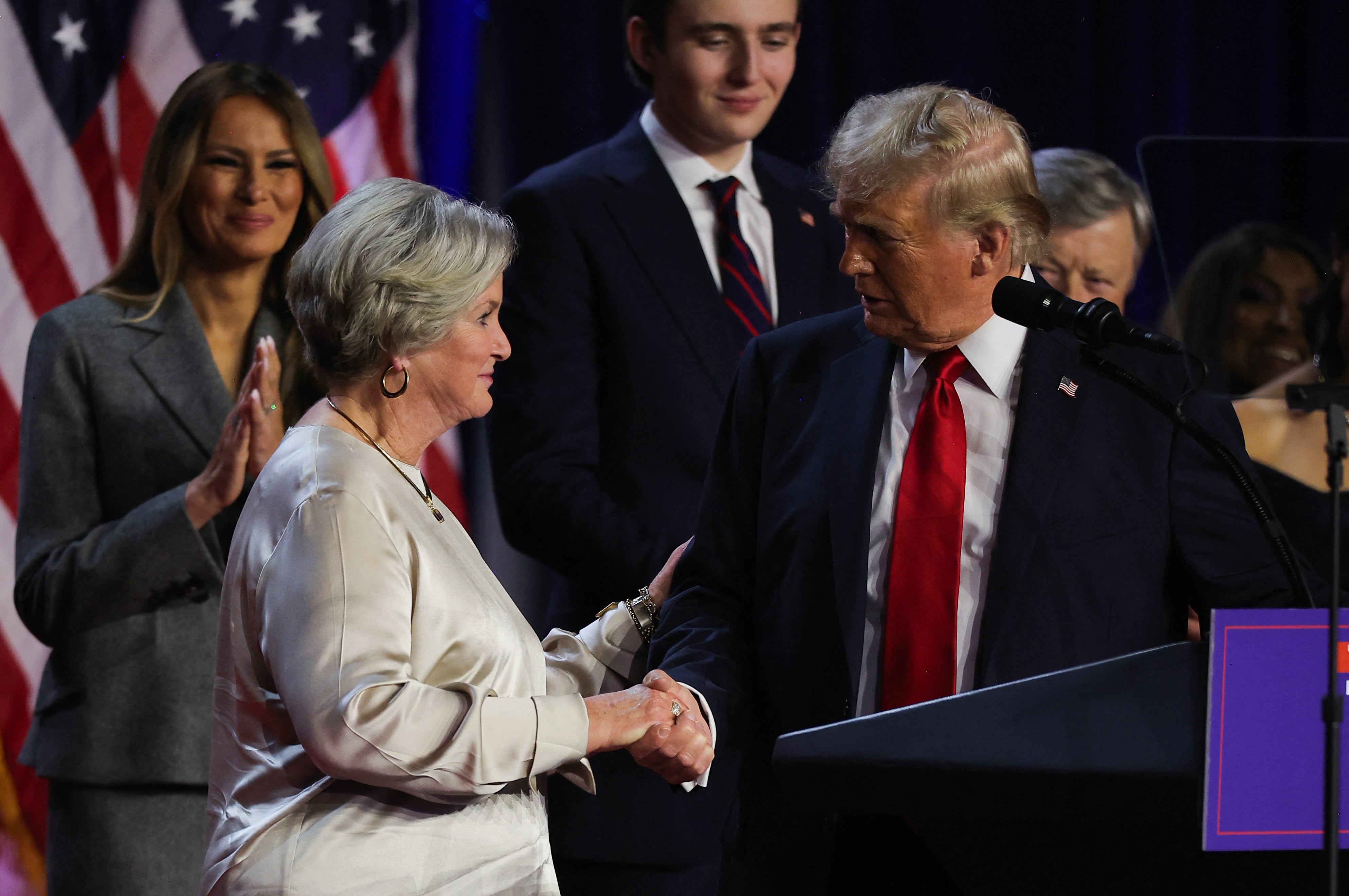 Republican presidential nominee and former U.S. President Donald Trump shakes hands with his senior advisor Susie Wiles