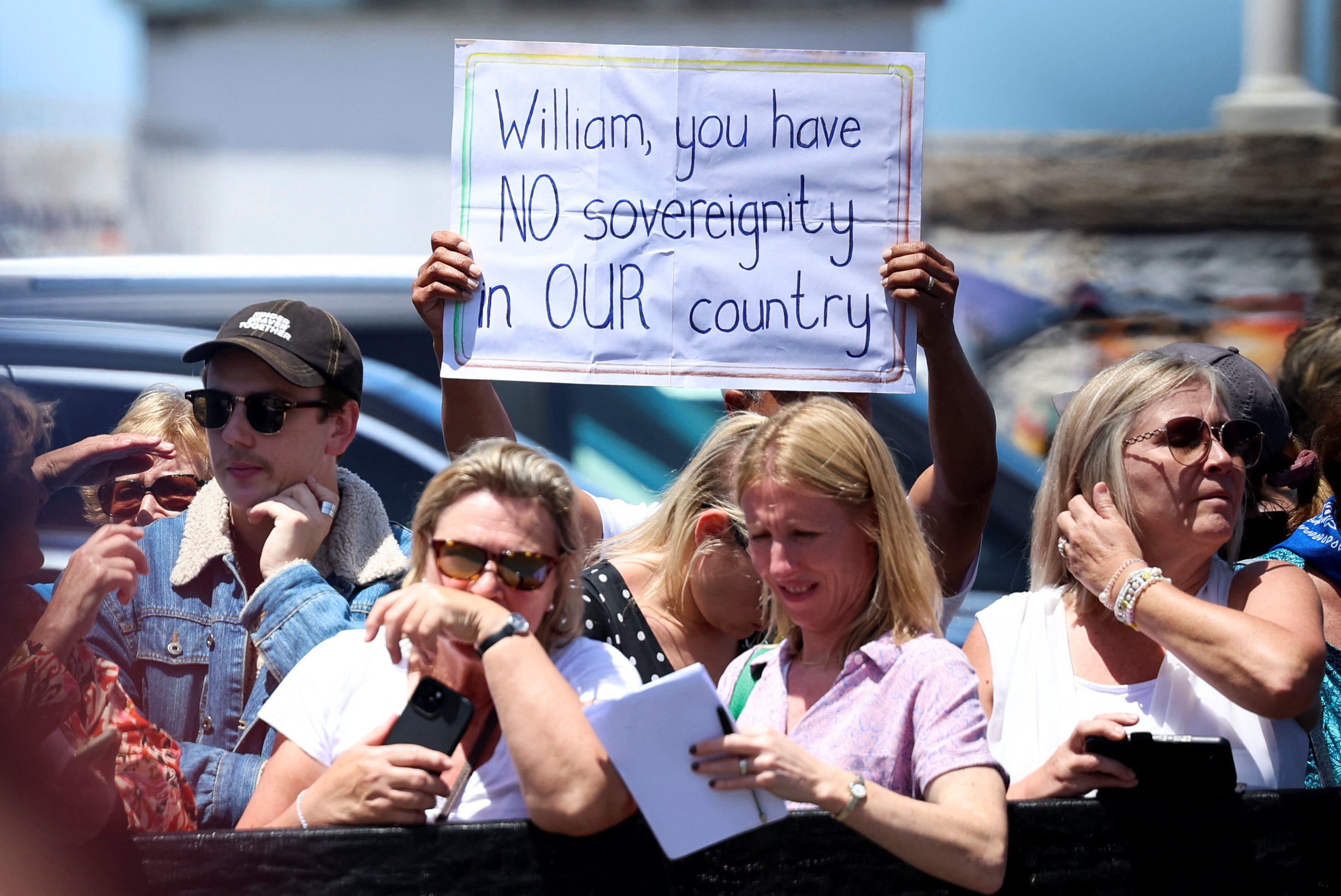 An anti-monarchy protester holds a placard on the day of Britain's Prince William visit to highlight the contributions of the 2023 Earthshot Prize finalists, Abalobi, at Kalk Bay Harbour in Cape Town, South Africa