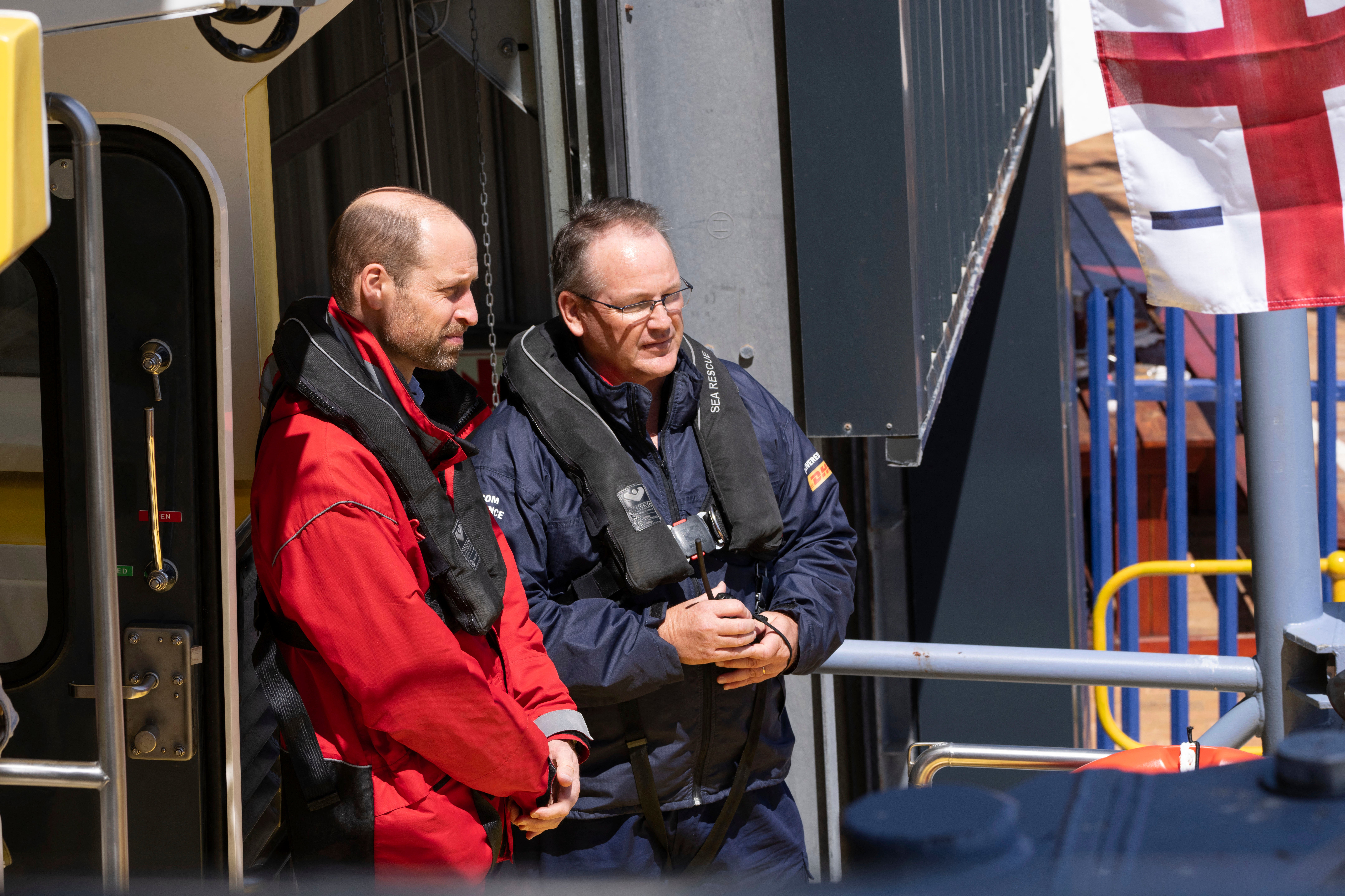 Prince William (L), Prince of Wales, sails off with volunteers from the National Sea Rescue Initiative (NSRI) near Simon's Town harbour