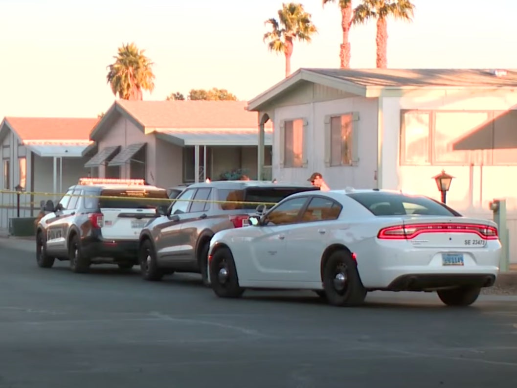 Police cars parked near the Nevada home of a 68-year-old woman whose body was found inside a freezer on Wednesday