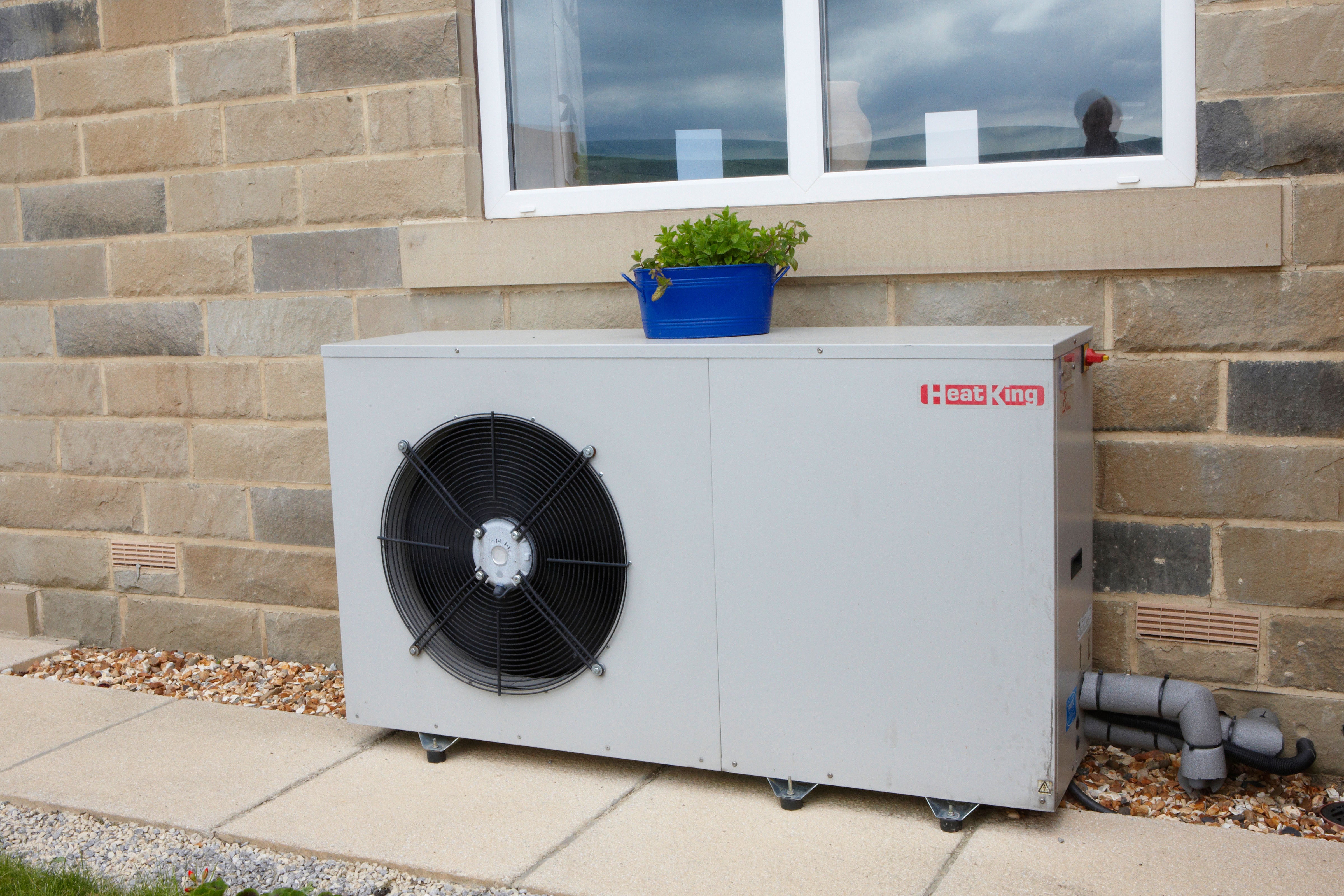 <p>An air source heat pump outside a house (Alamy/PA)</p>