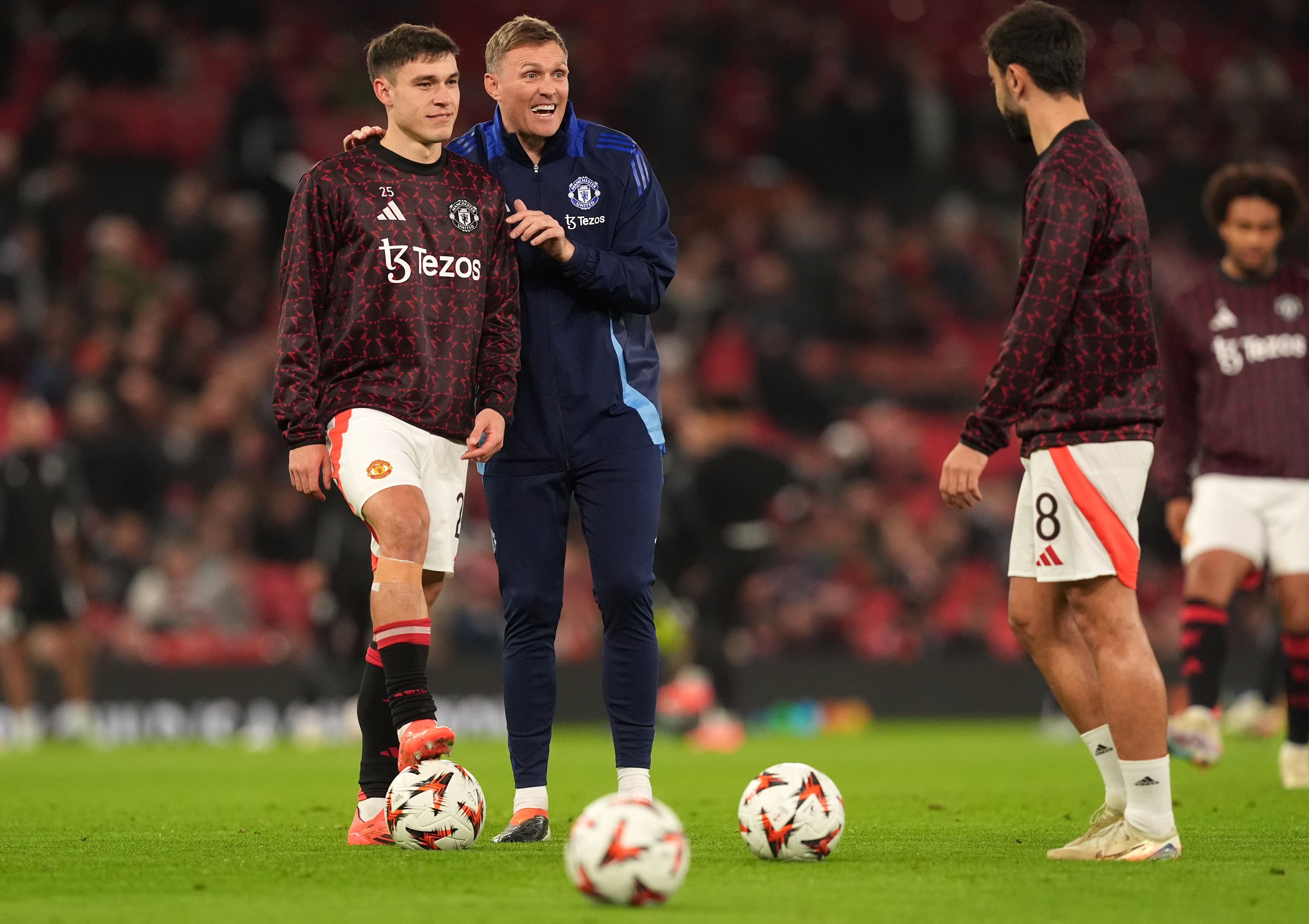 Coach Darren Fletcher and midfielder Manuel Ugarte speak to captain Bruno Fernandes