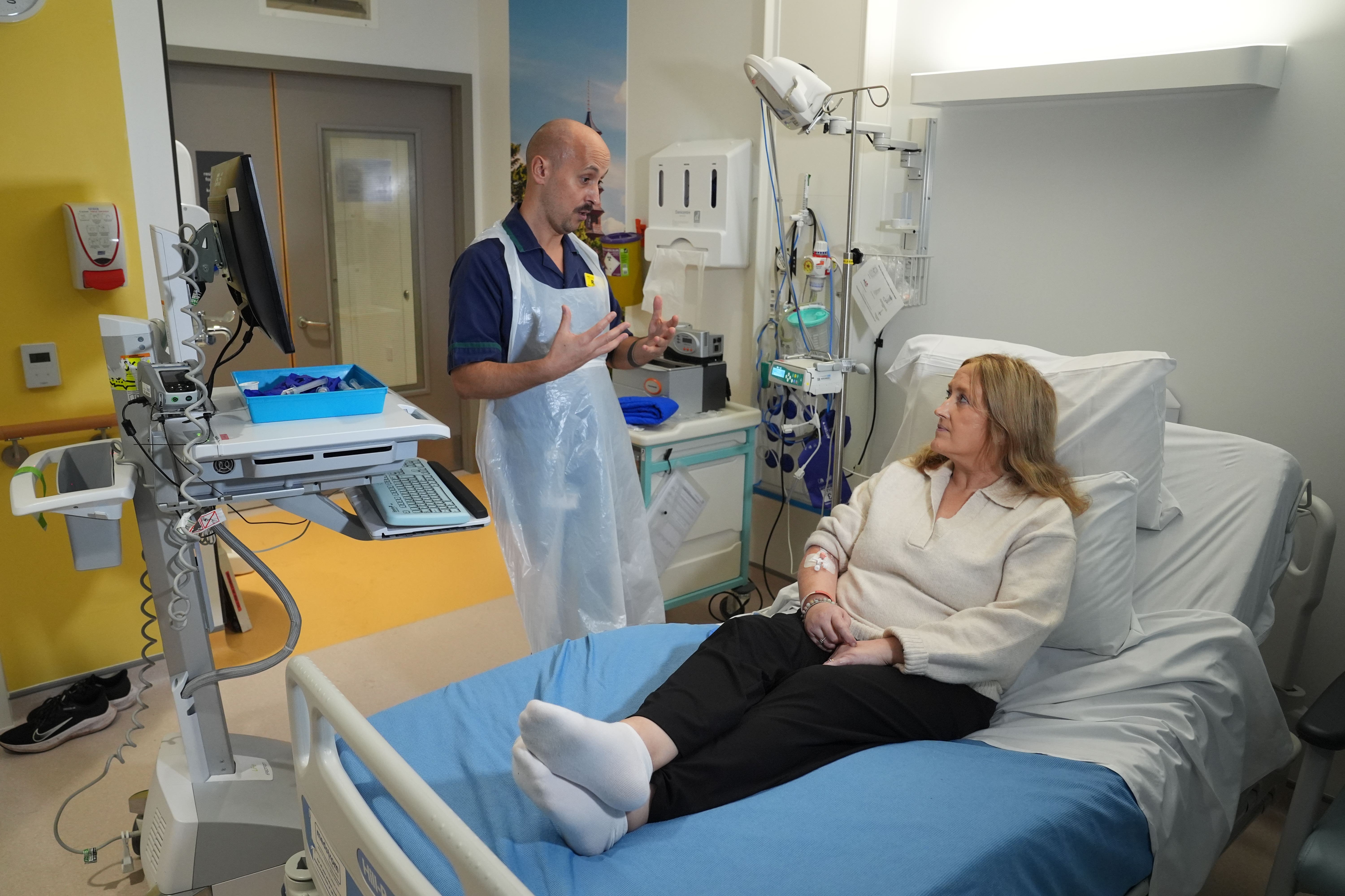 Senior clinical practice facilitator Rob McDonnell discussing with patient Katie Tinkler before she receives a breakthrough treatment for lupus at University College London Hospital in London (Lucy North/PA)