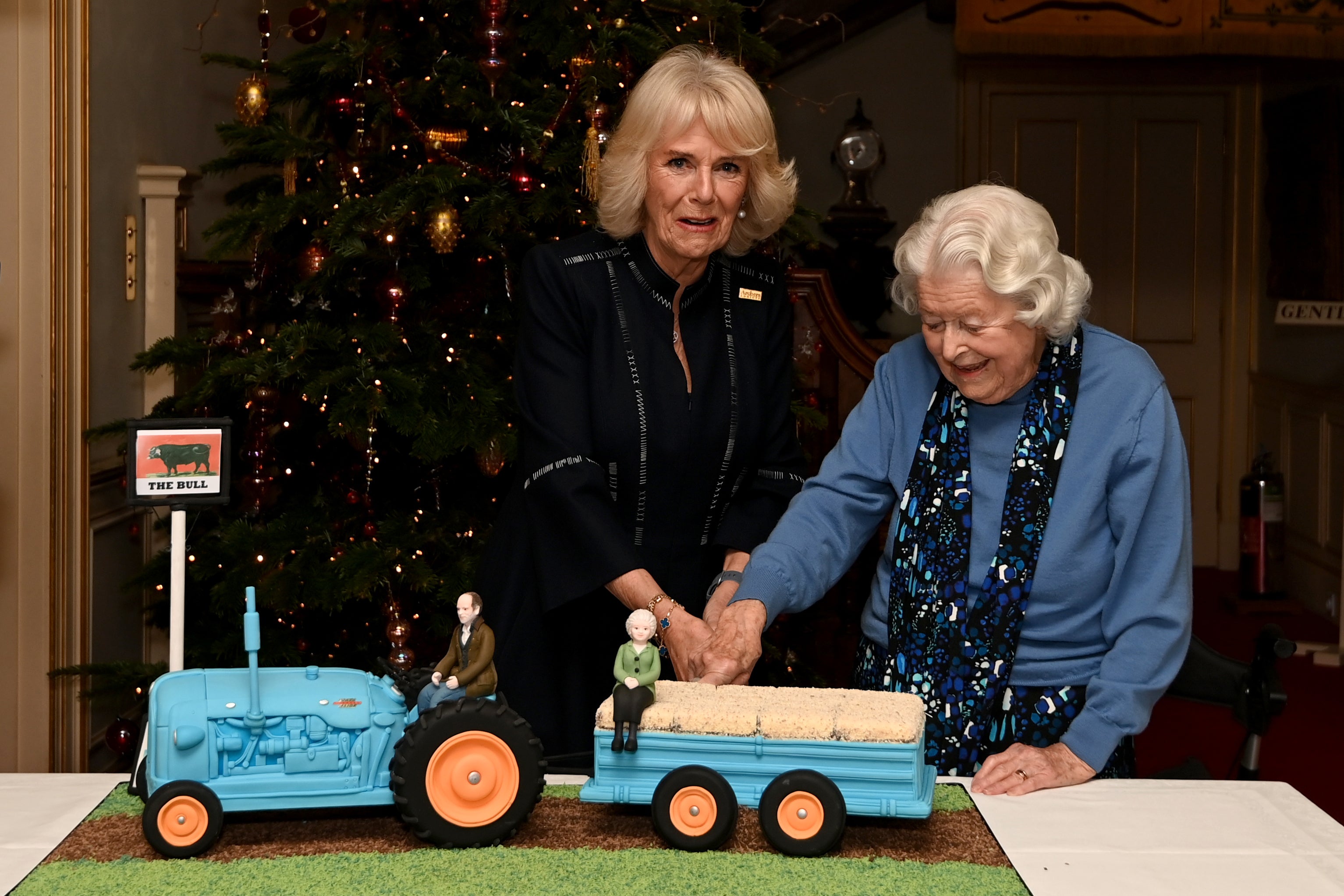 Queen Camilla and June Spencer cut an Archers themed cake during a celebration of the programme’s 70th anniversary