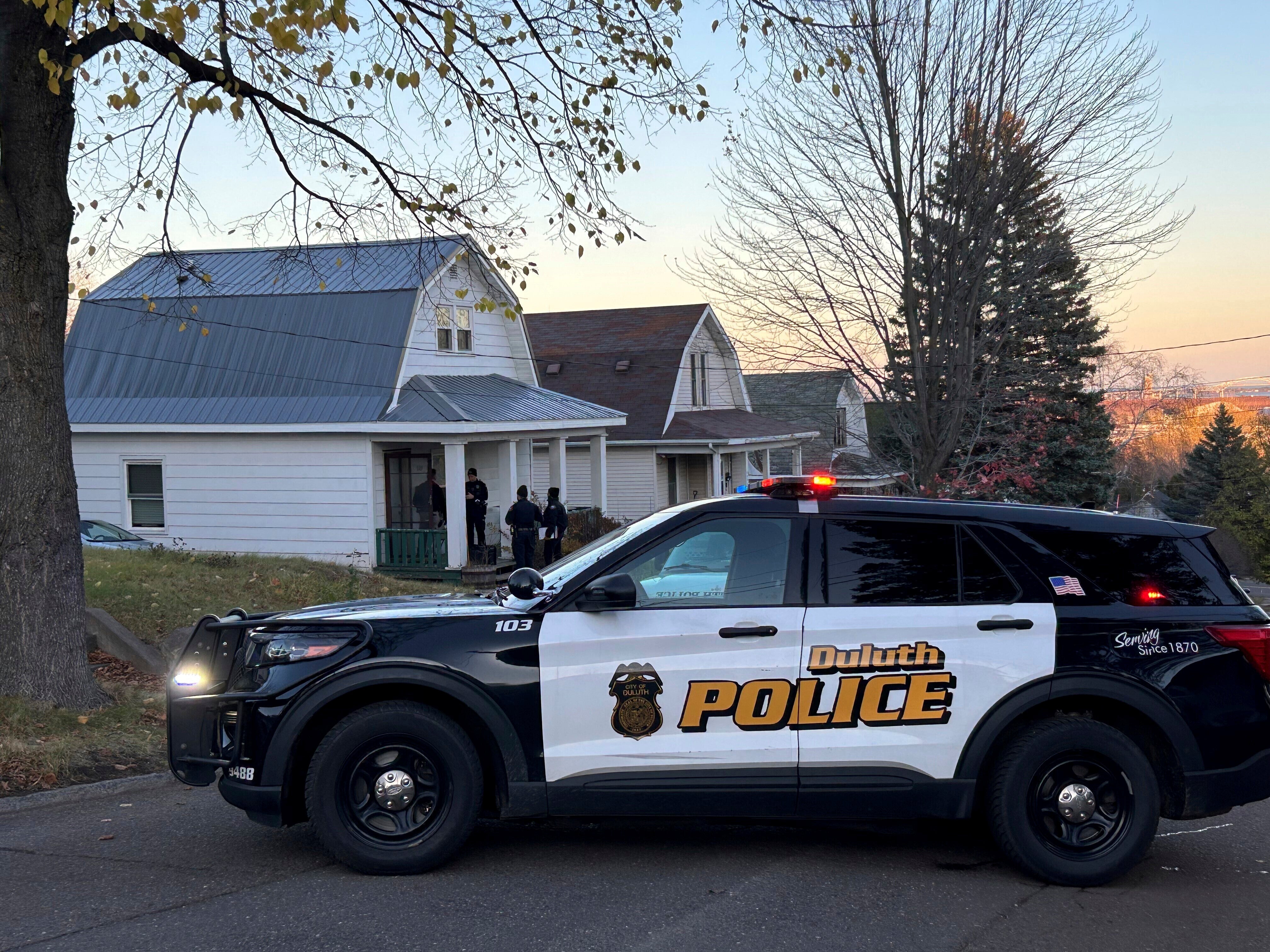 Police investigate the scene where five people were found shot to death inside two homes in Duluth