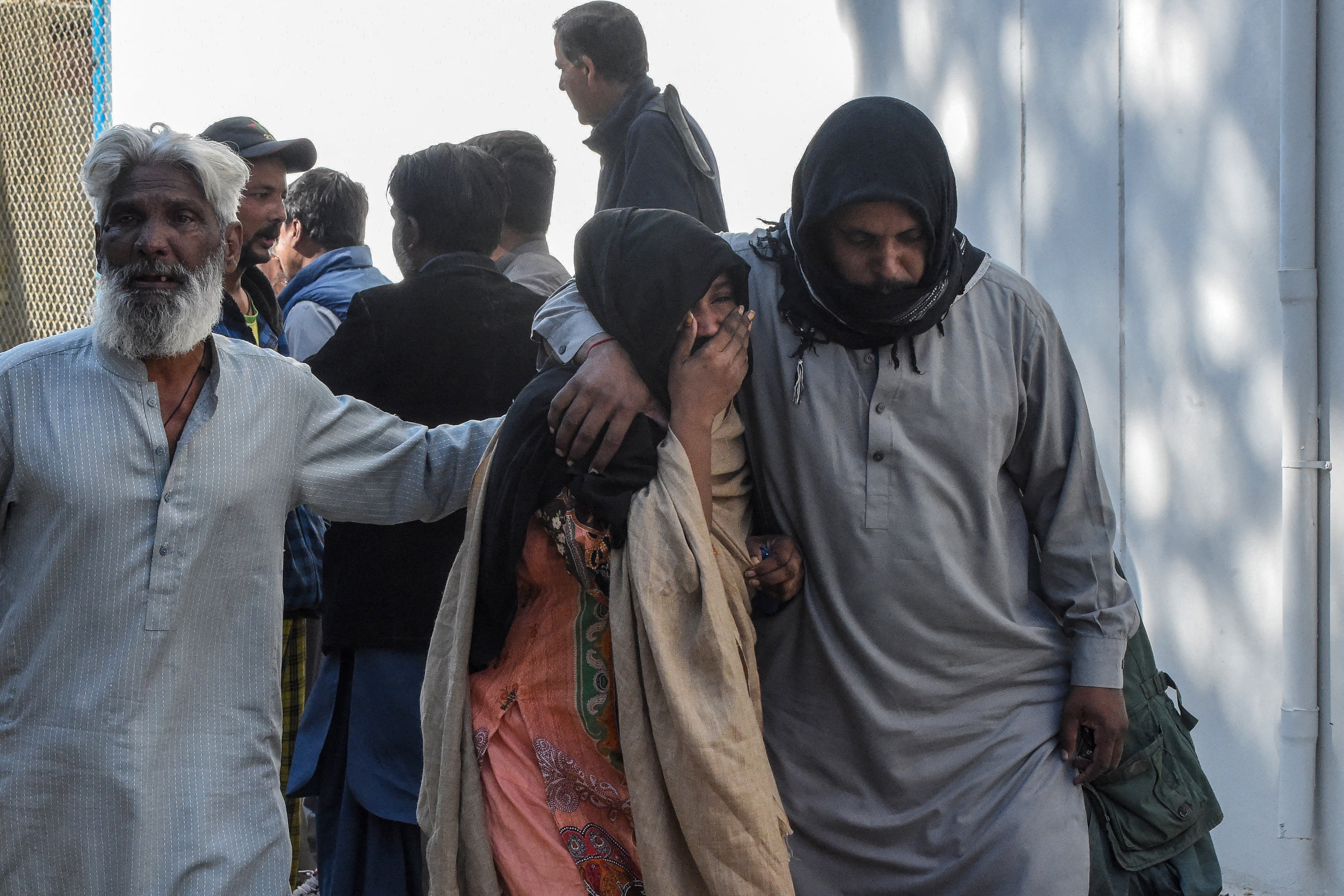 People mourn deaths of relatives outside a hospital