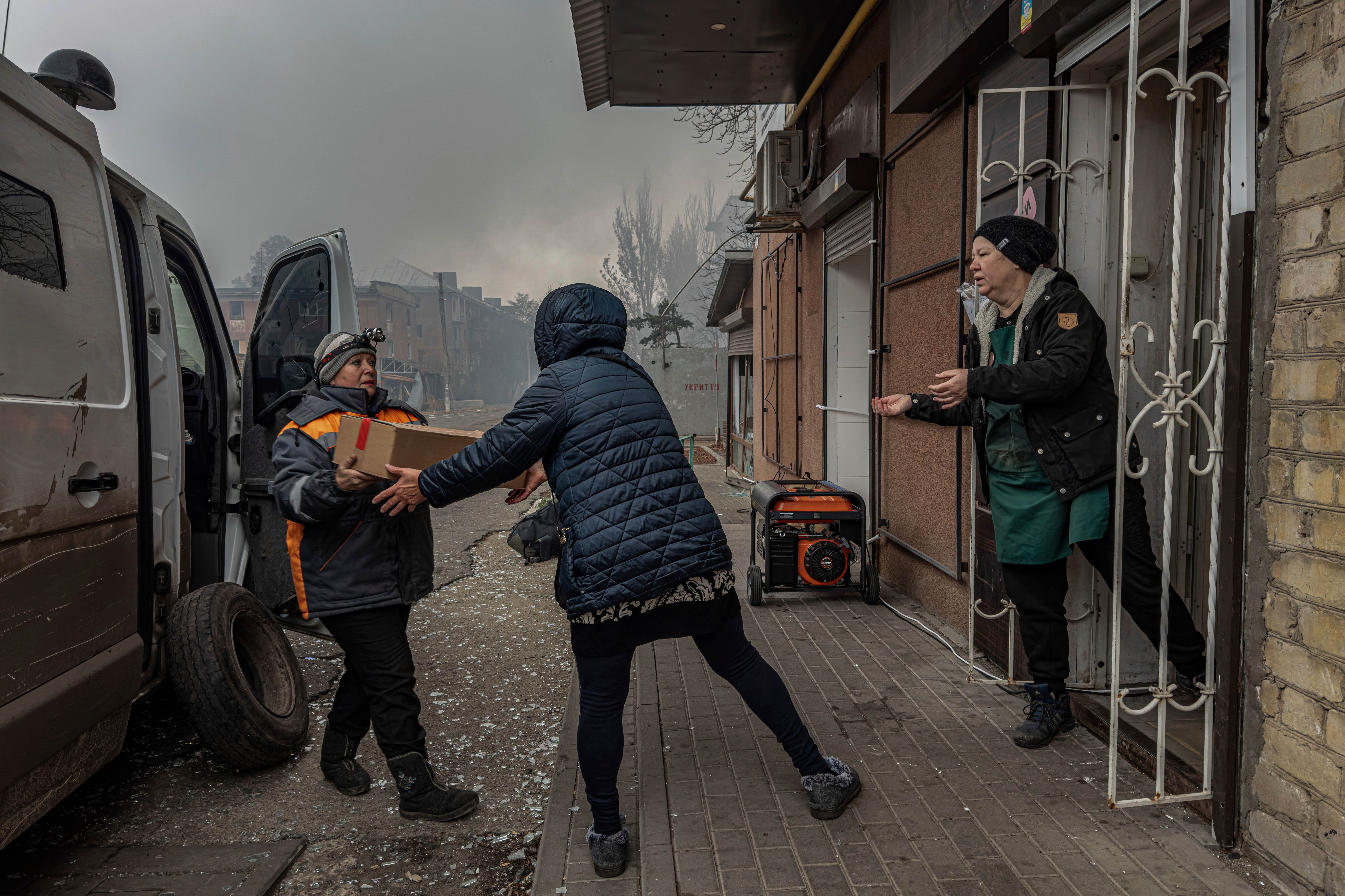 Local women unload food products from a minivan into the last shop operating in Kurakhove, Donetsk region, Ukraine