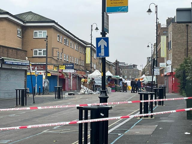 <p>Police forensics at the scene of a triple stabbing at a busy market in East Street, south London</p>