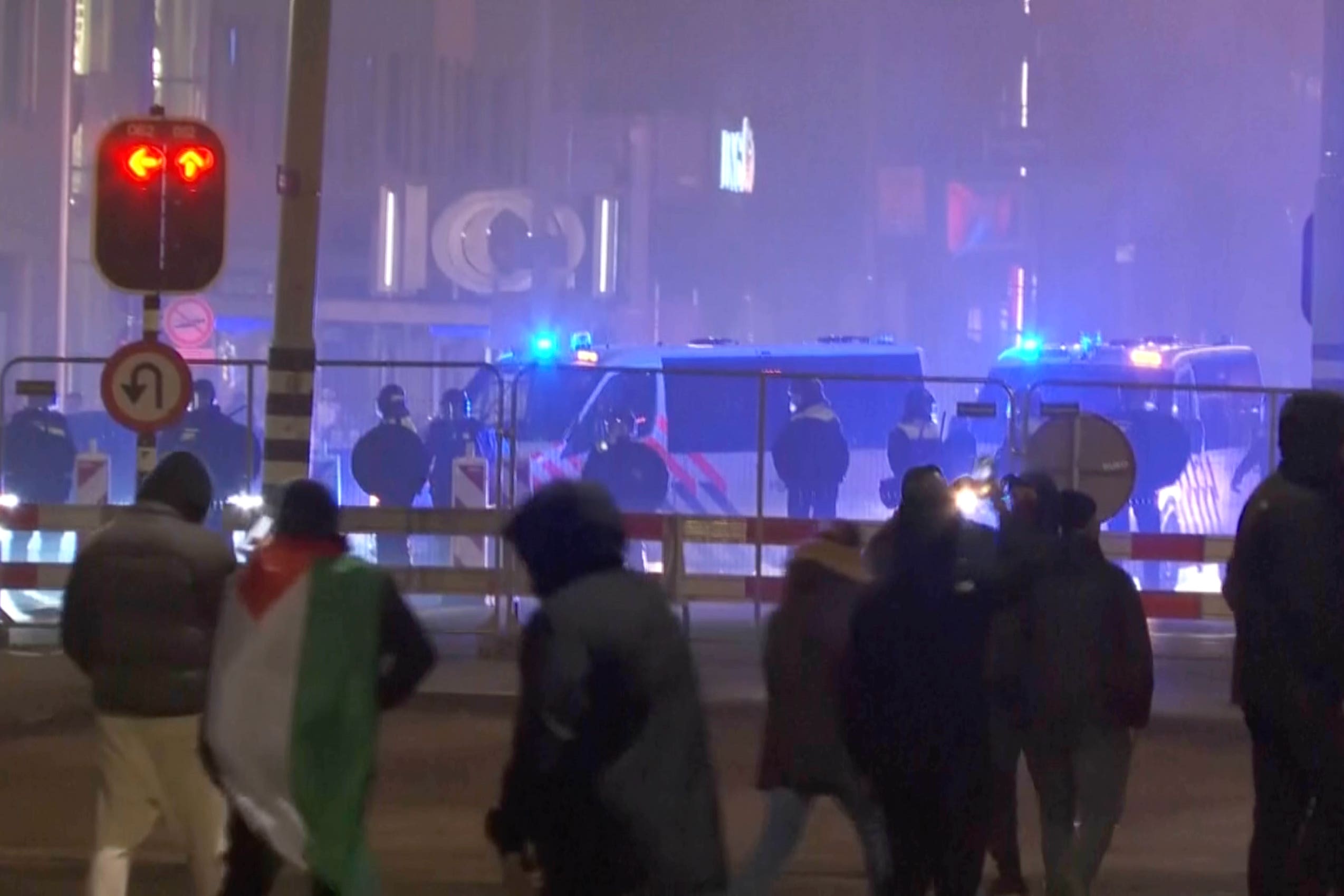 In this image taken from video, a group of pro-Palestinian protesters walk towards police line, with police vans driving in the background, near the soccer stadium in Amsterdam, Netherlands (RTL Nieuws via AP)