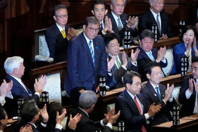 <p>Lawmakers applaud as prime minister Shigeru Ishiba, standing, is re-elected in a special parliamentary session in the lower house, Monday, 11 November 2024 in Tokyo</p>