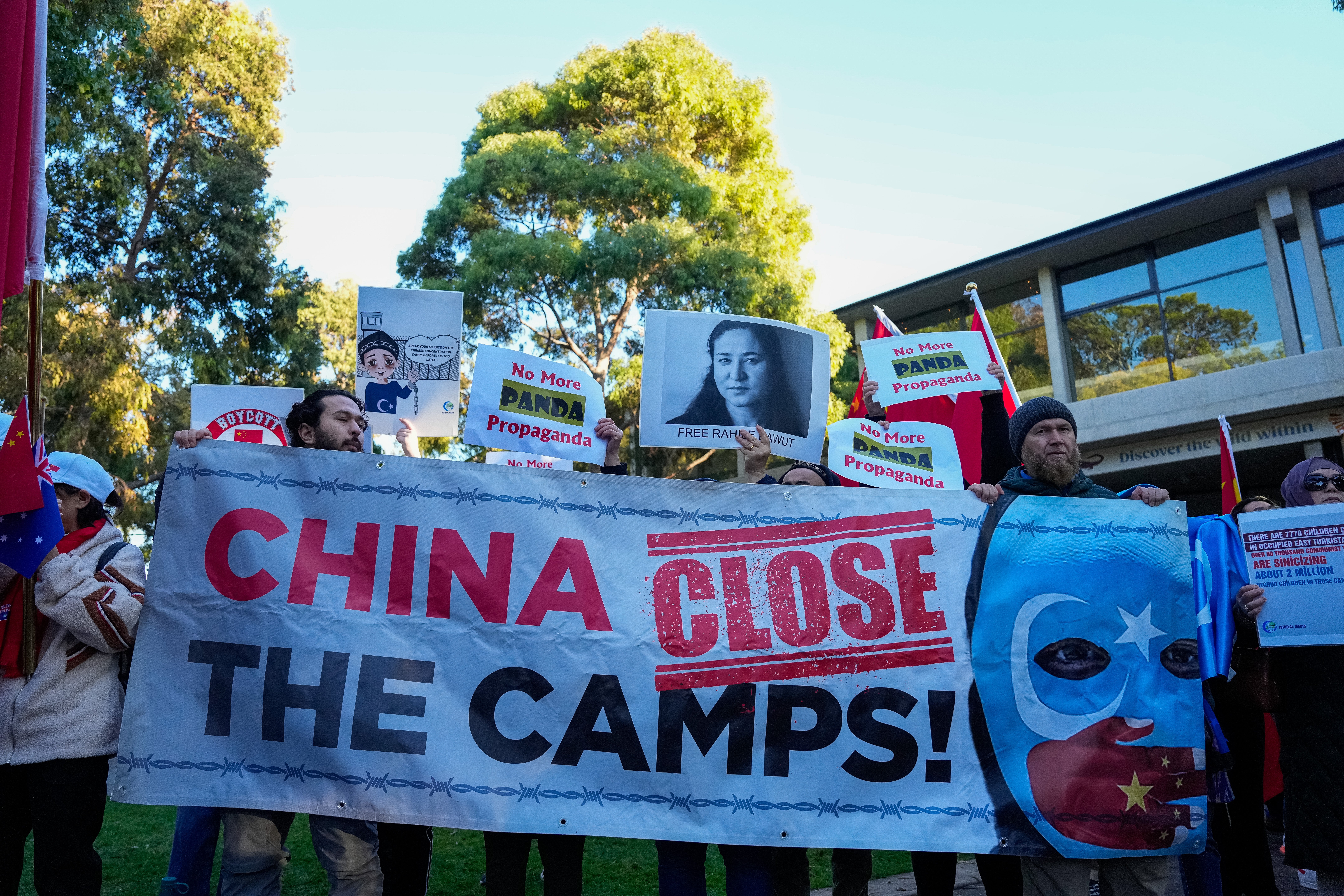 <p>Uyghur and counter China protestors holding placards outside the Adelaide Zoo in Australia</p>