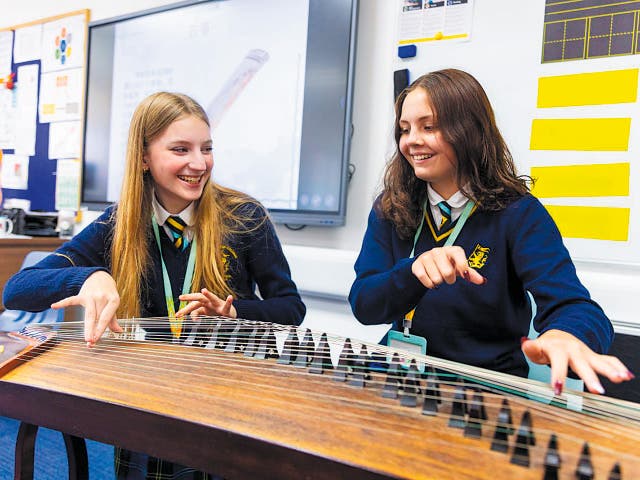 <p>Two students from Wellington College in Shanghai try a classical Chinese musical instrument</p><p></p>