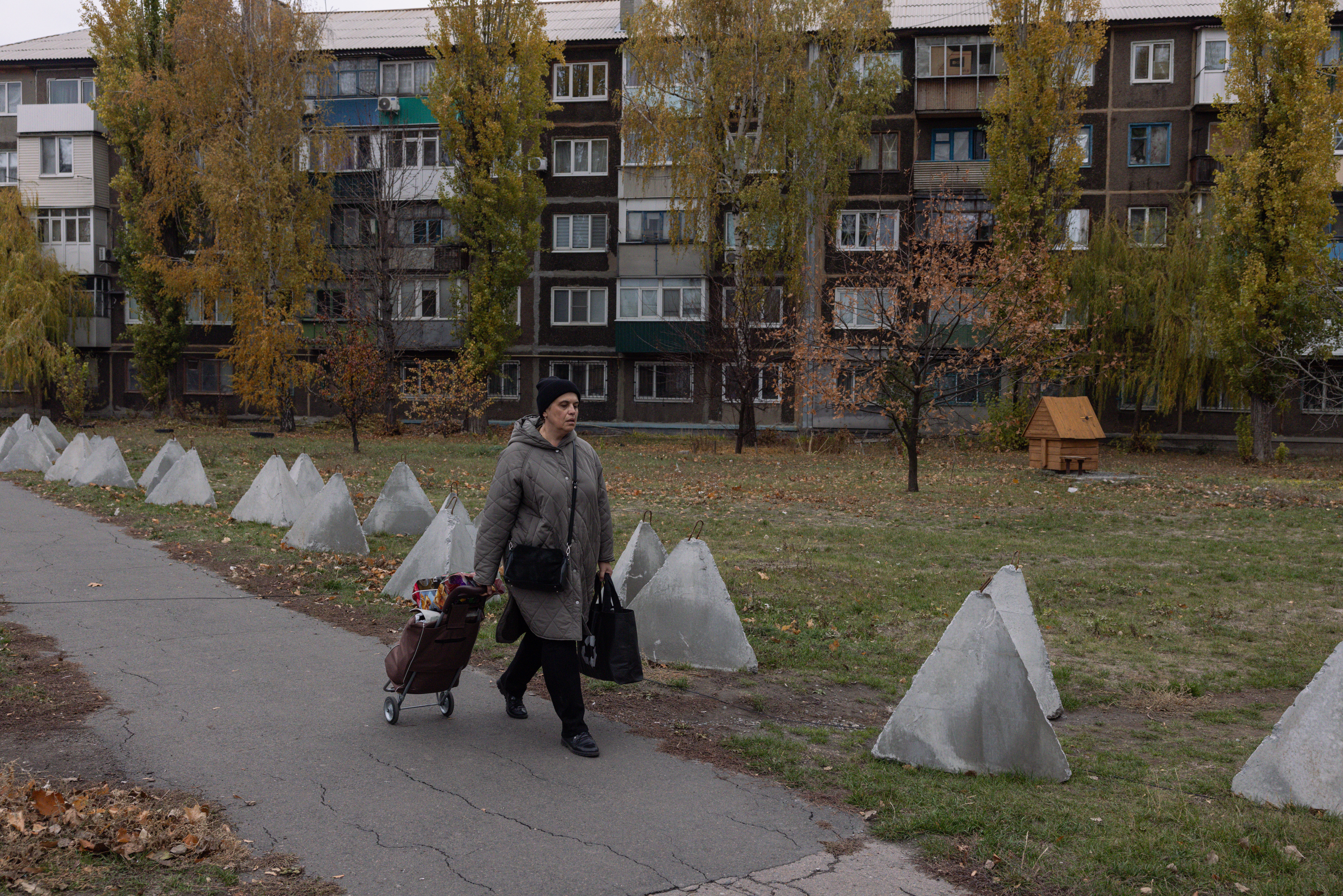 A lady walks with a shopping trolley along a line of dragon’s teeth in the eastern part of the city