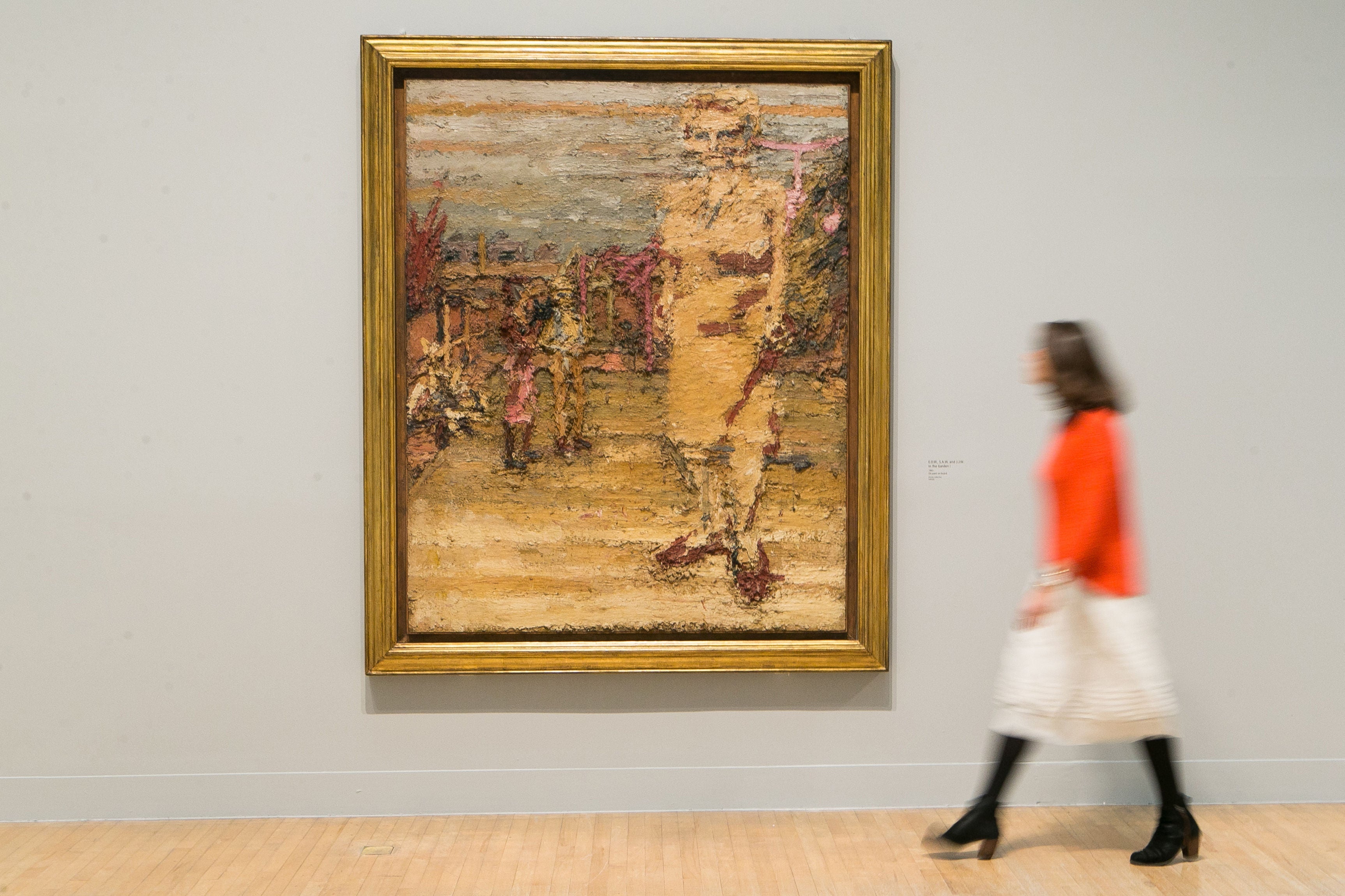 A gallery employee looks at a painting by Frank Auerbach called 'EOW., SAW, and JJW. in the Garden I', 1963, at a photocall for a new exhibition by the British artist at the Tate Britain in London.