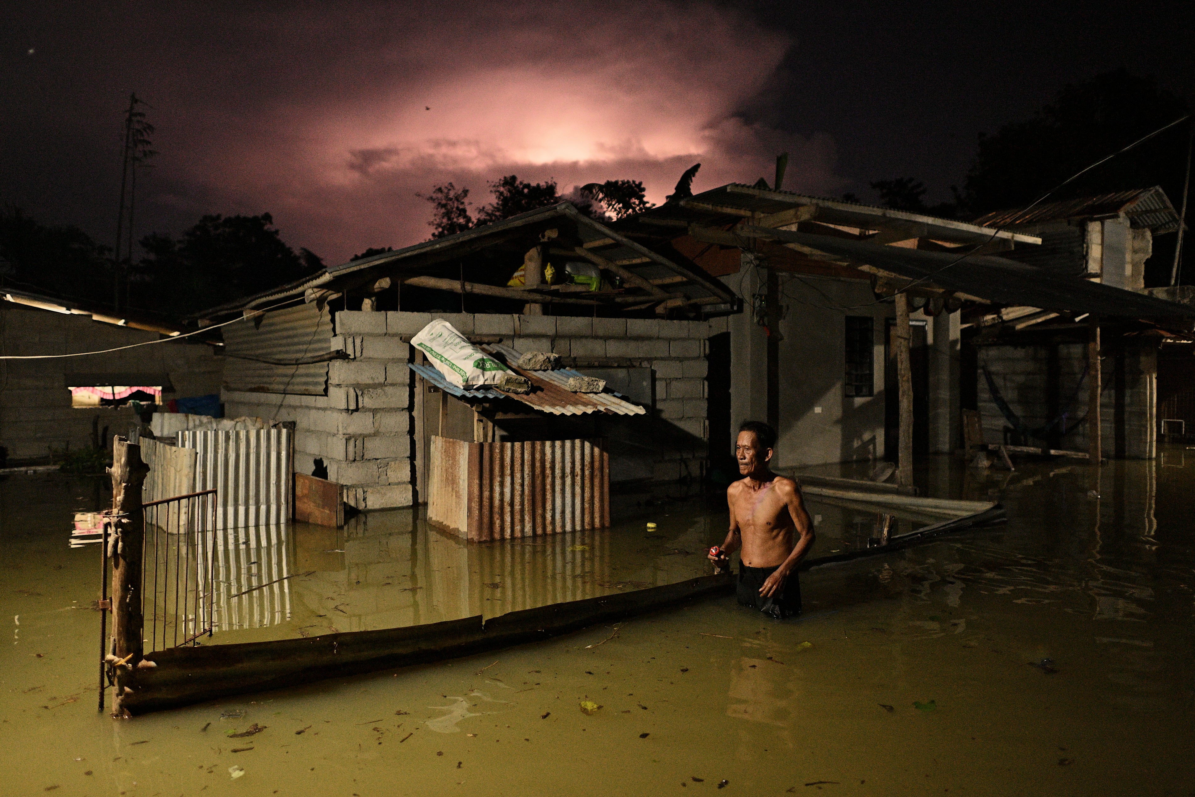<p>A resident wades through a flooded street caused by heavy rains from typhoon Toraji in Ilagan City, Isabela province, northern Philippines on Tuesday, 12 November 2024</p>