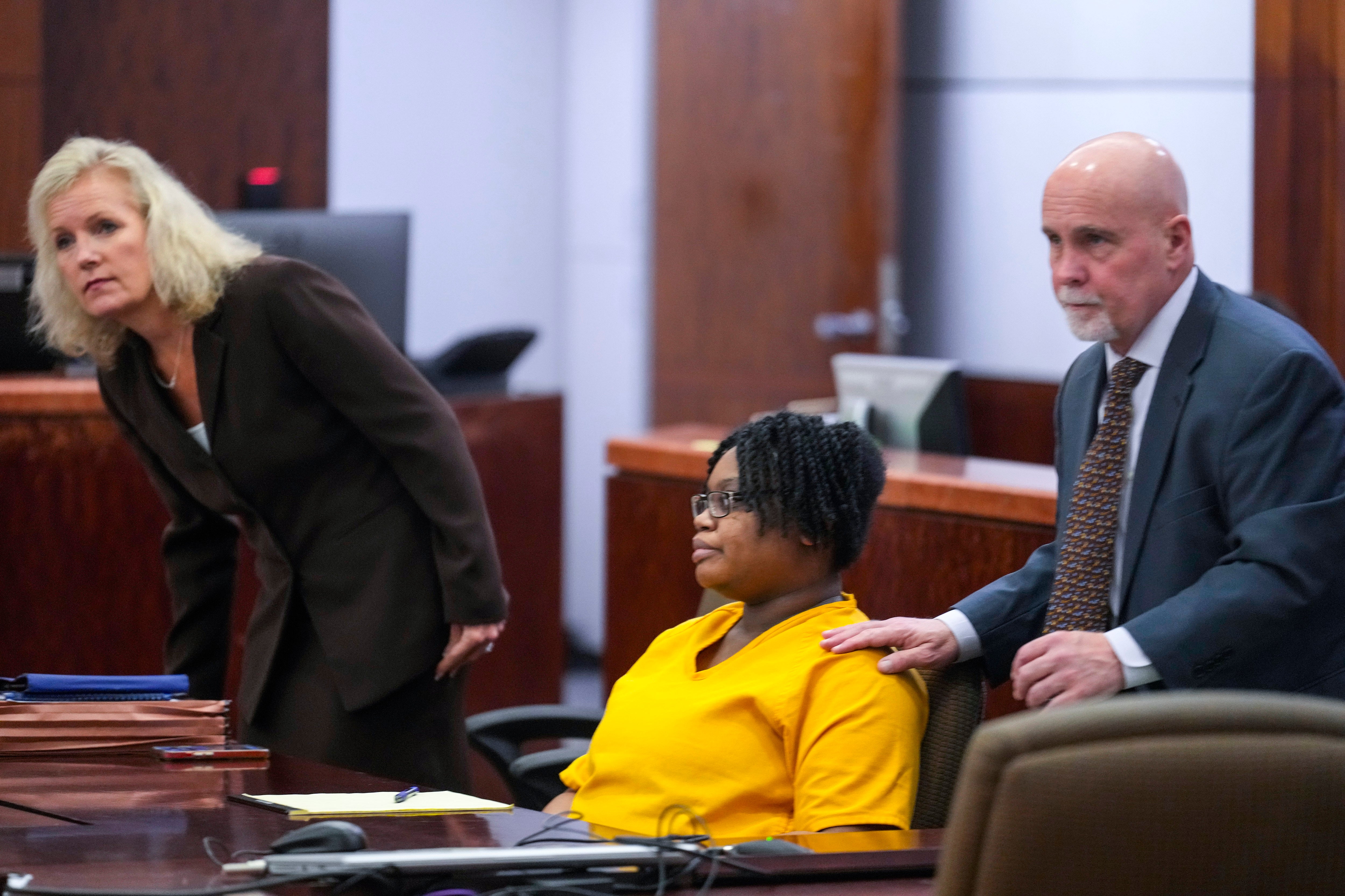 Defendant Gloria Williams, charged in connection with the death of her eight-year-old son, whose skeletal remains decomposed for months inside a Houston-area apartment with three surviving but abandoned siblings, and her lawyers, Beth Exley, left, and Neal Davis III, appear for a hearing