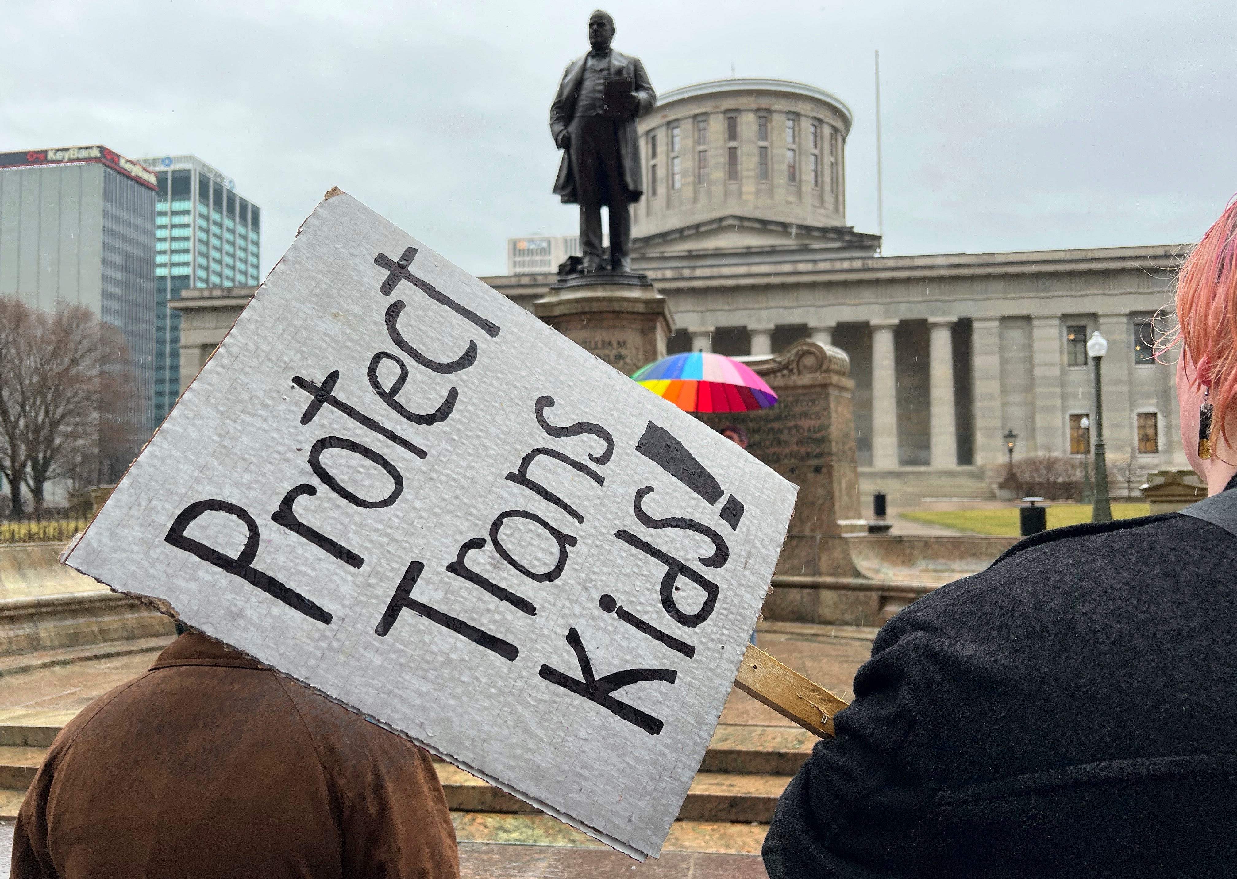 Protesters advocating for transgender rights and healthcare stand outside of the Ohio Statehouse,