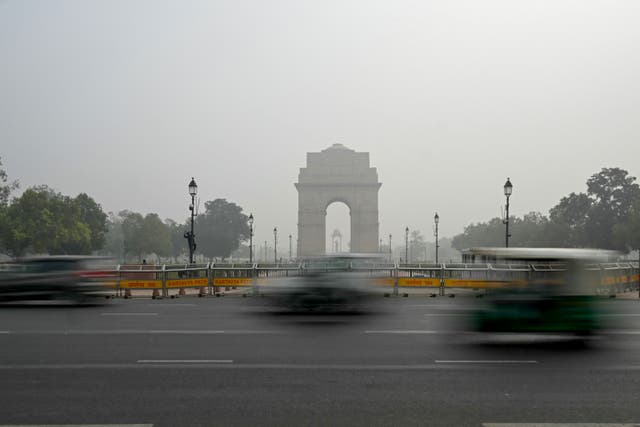 <p>Commuters drive past India Gate engulfed in smog in New Delhi </p>