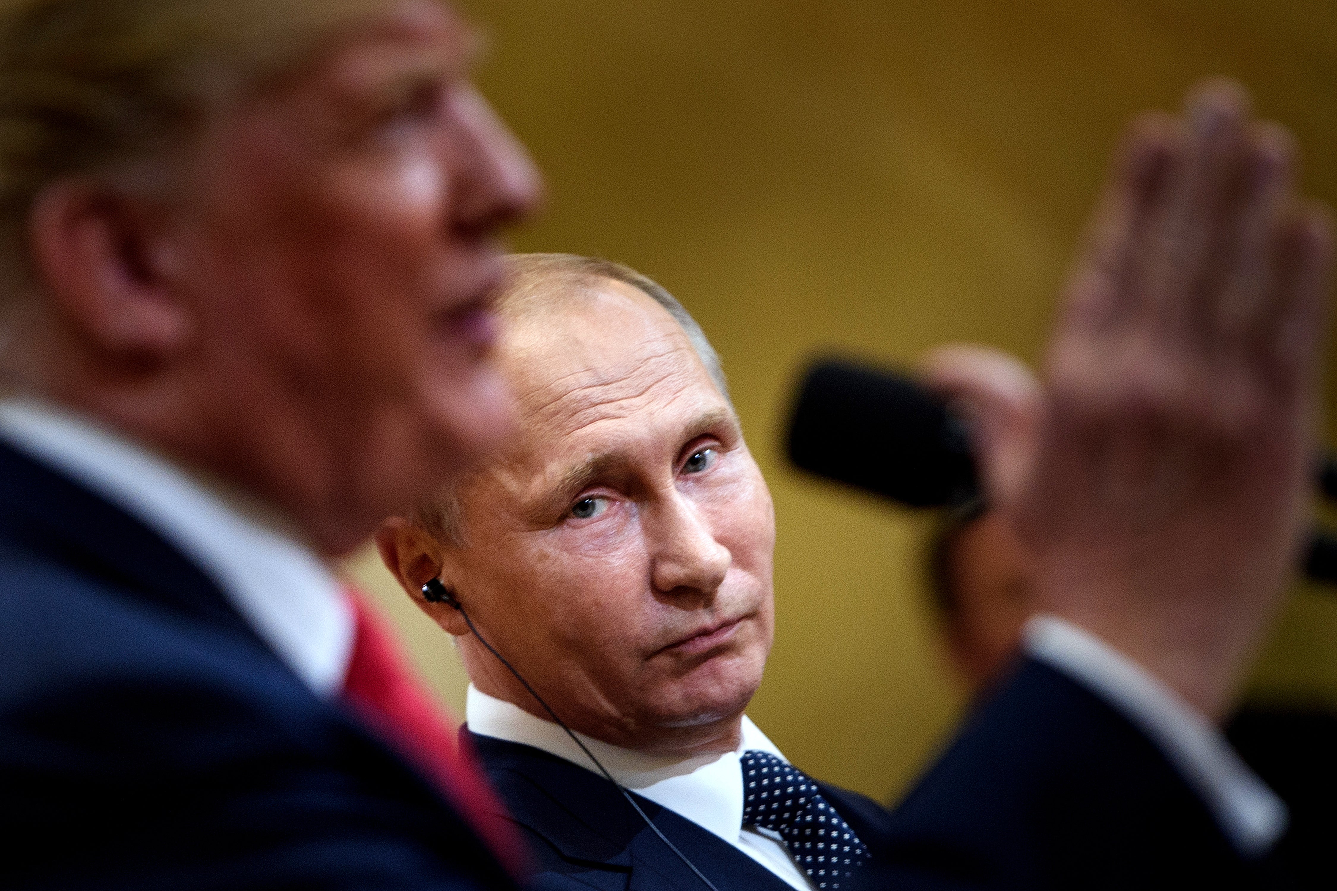 Vladimir Putin listens to Donald Trump during a press conference in Helsinki, Finland, in 2018