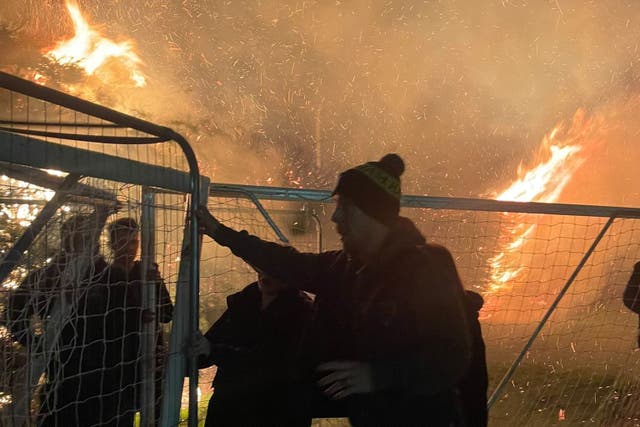 <p>Brave parents move play equipment way from the inferno at Halisham Football Club </p>