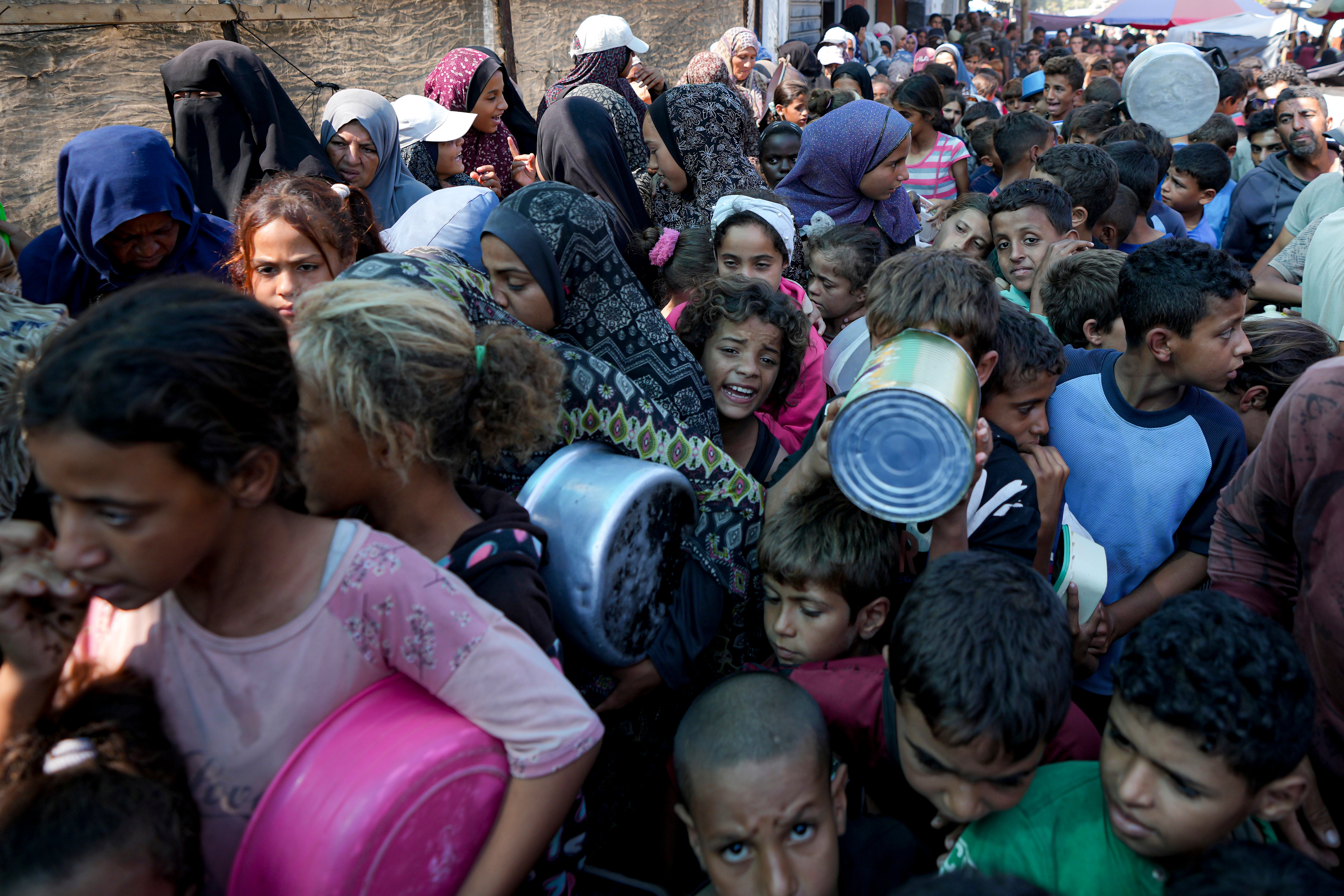 Palestinians line up for food distribution in Deir al-Balah, Gaza Strip, on 17 October