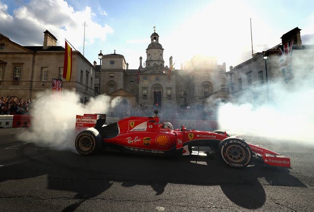 <p>Sebastian Vettel performs doughnuts in his Ferrari car at F1 Live London in 2017</p>