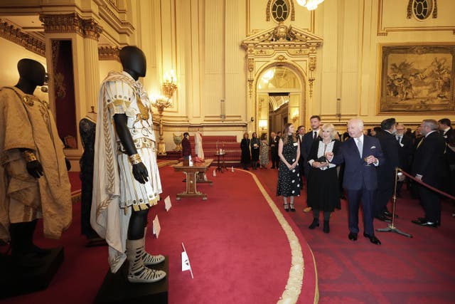 The King and Queen view costumes and items from films during a reception to mark the centenary of the Film and TV charity, at Buckingham Palace, London (Aaron Chown/PA)