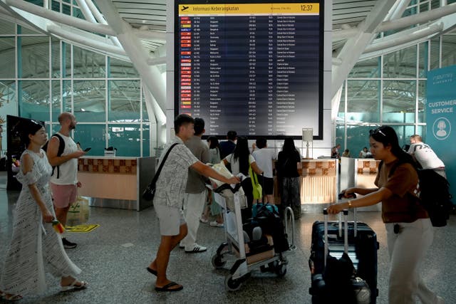 <p>Passengers look at an electronic board displaying cancelled flights after the nearby Mount Lewotobi Laki-Laki volcano catapulted an ash tower </p>