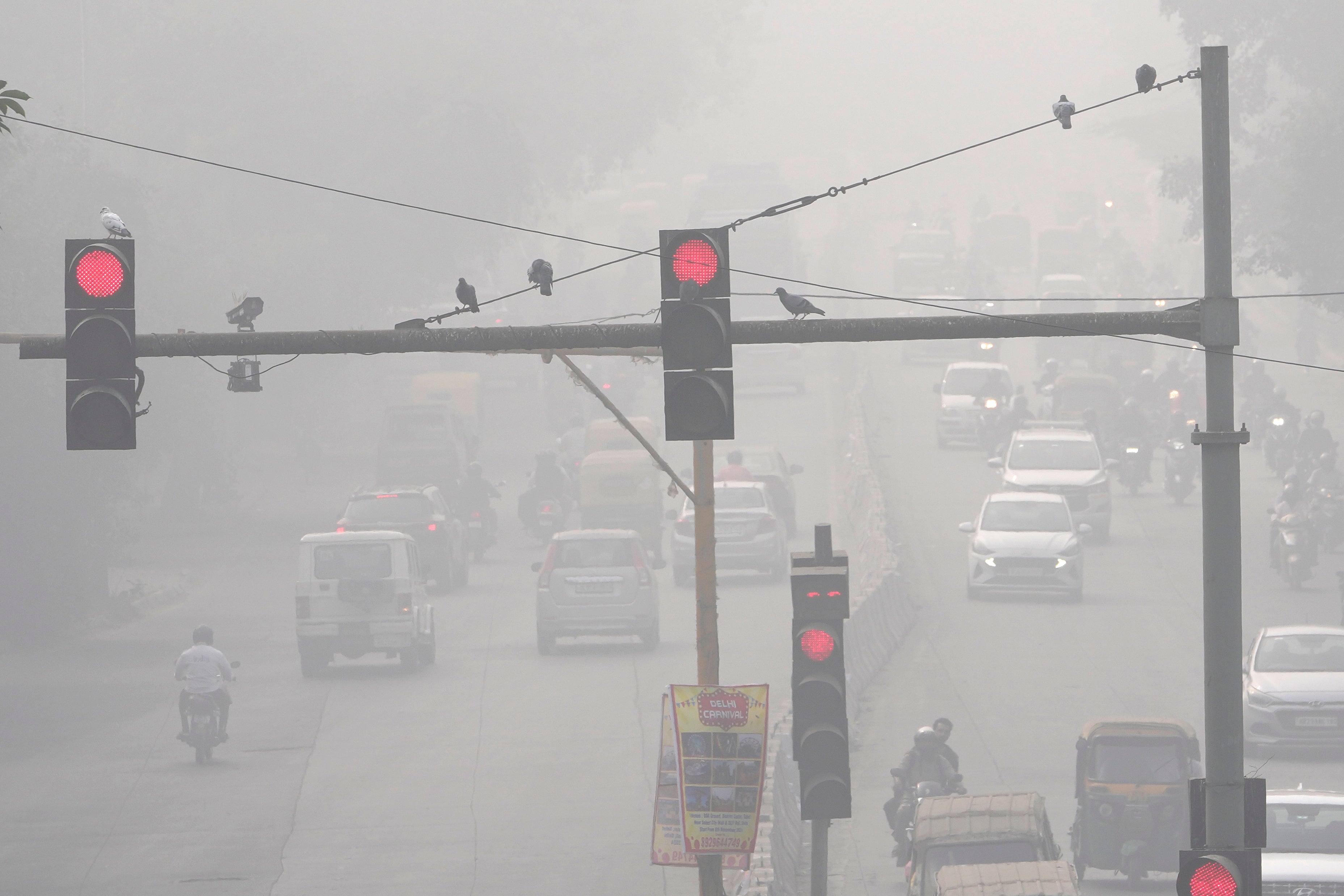 Traffic moves through thick smog in Delhi