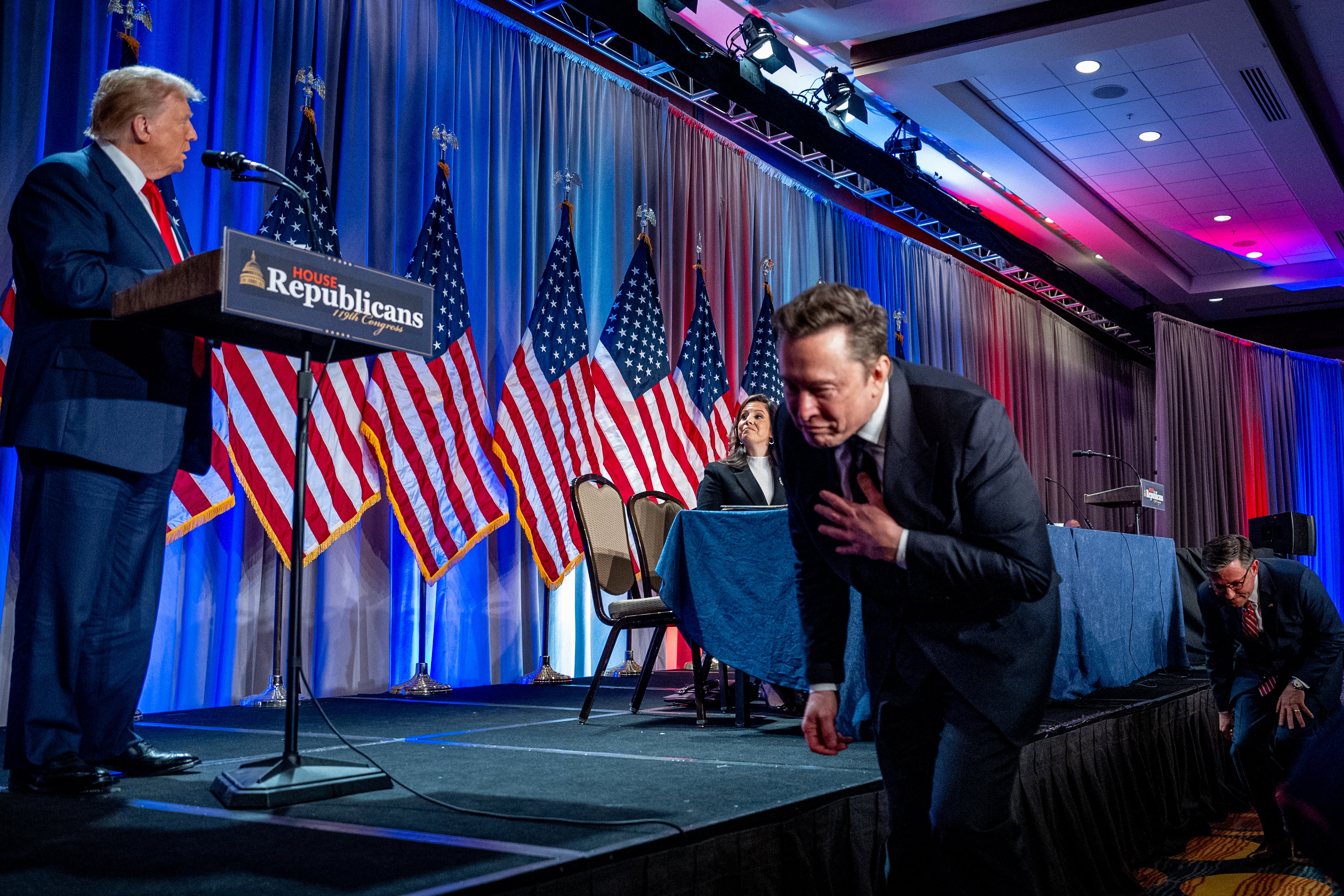 US Speaker of the House Mike Johnson (R) escorts Elon Musk (2nd-R) as he arrives with U.S. President-elect Donald Trump (L) at a House Republicans Conference meeting