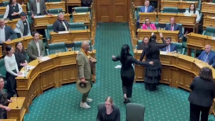 Moment New Zealand MPs disrupt parliament with haka to protest treaty bill.