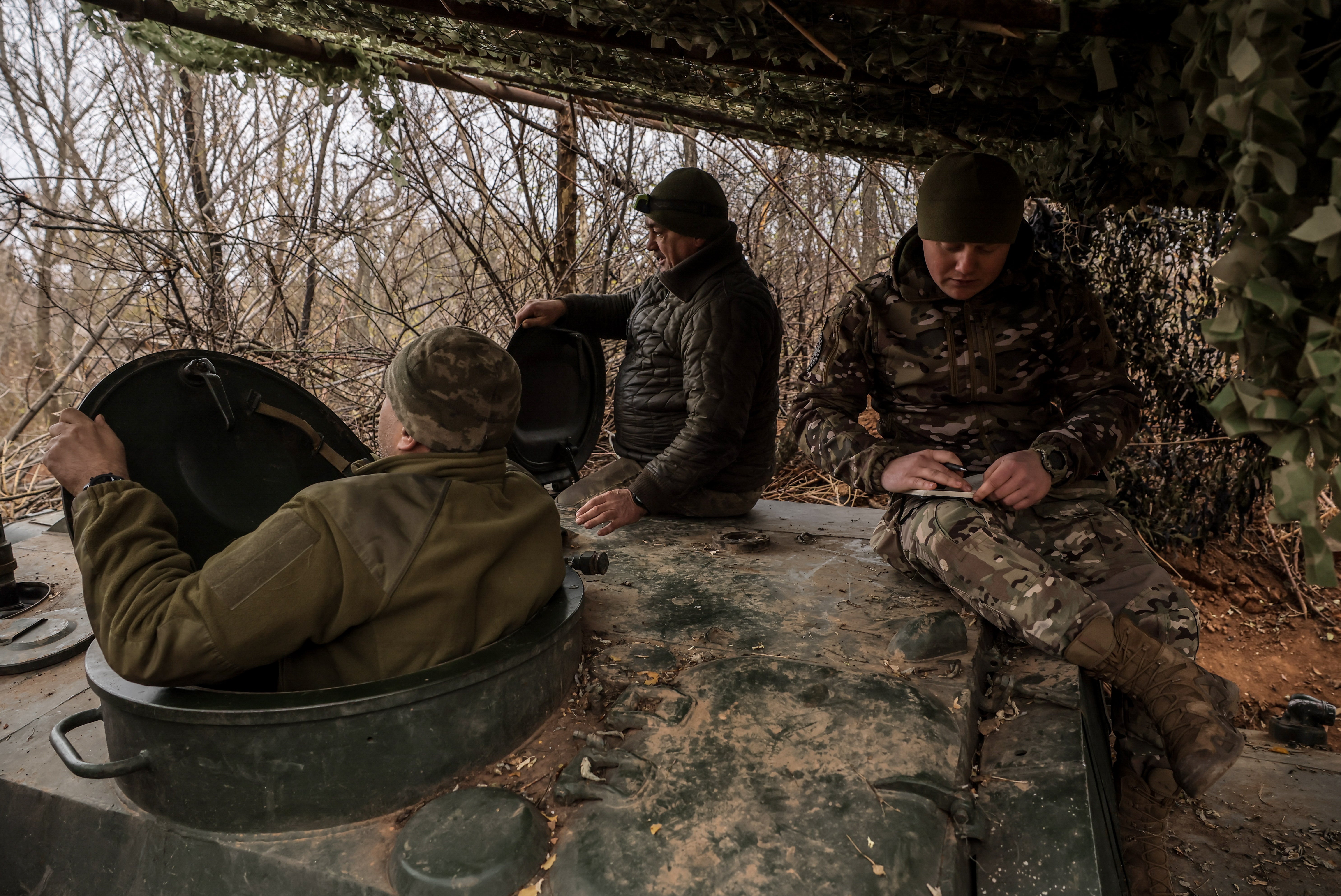 Ukrainian soldiers from the artillery unit of the 24th Mechanized Brigade sit at their position near Chasiv Yar, Donetsk region