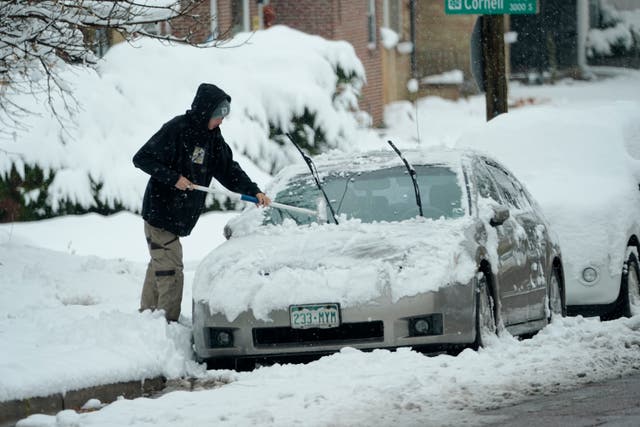 <p>A person clears snow off of a car in Englewood, Colorado, last week. The state had its first snowstorm of the season and more is expected this week. </p>