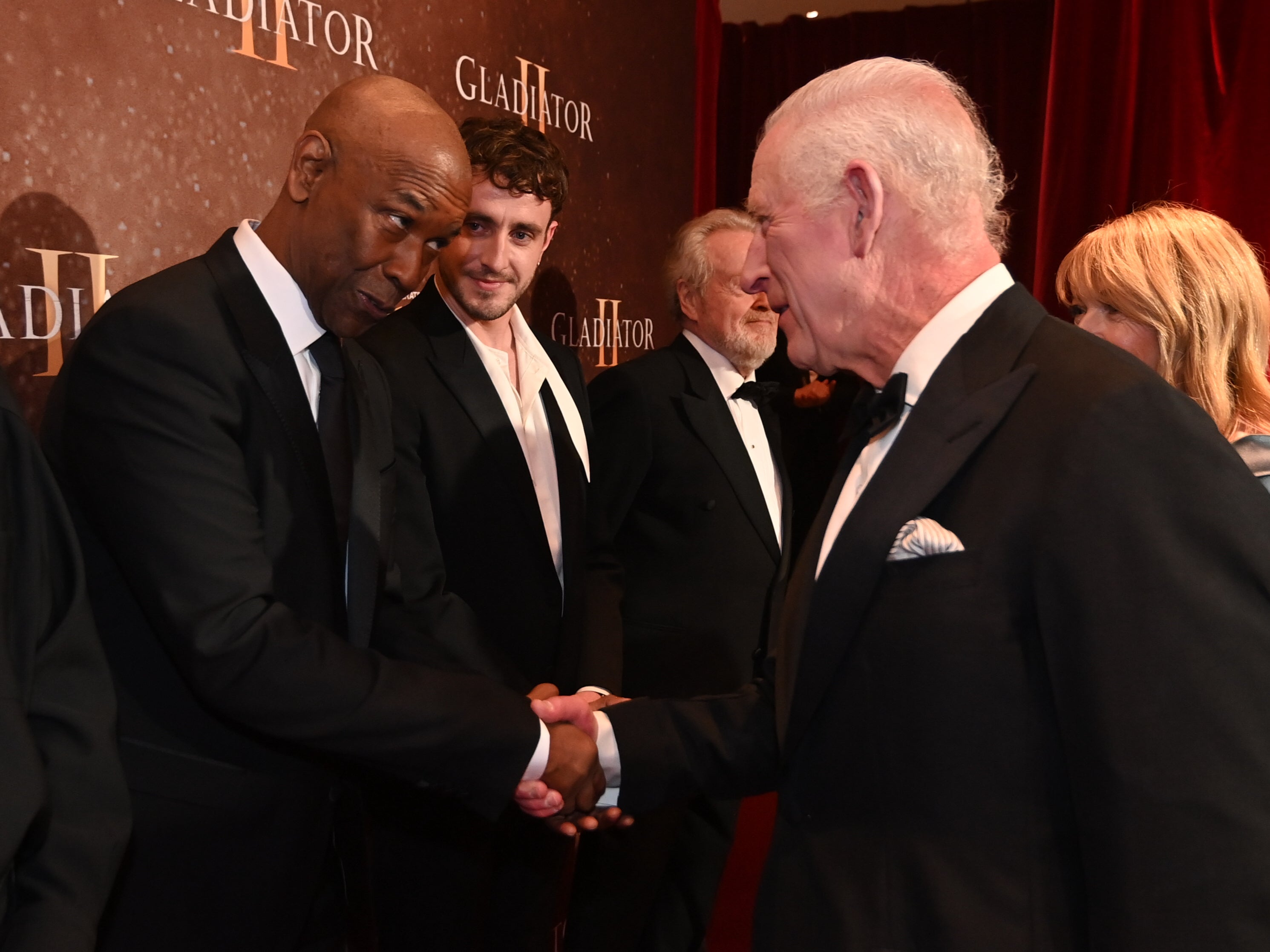 Denzel Washington nervously shakes King Charles III’s hand at the ‘Gladiator II’ premiere