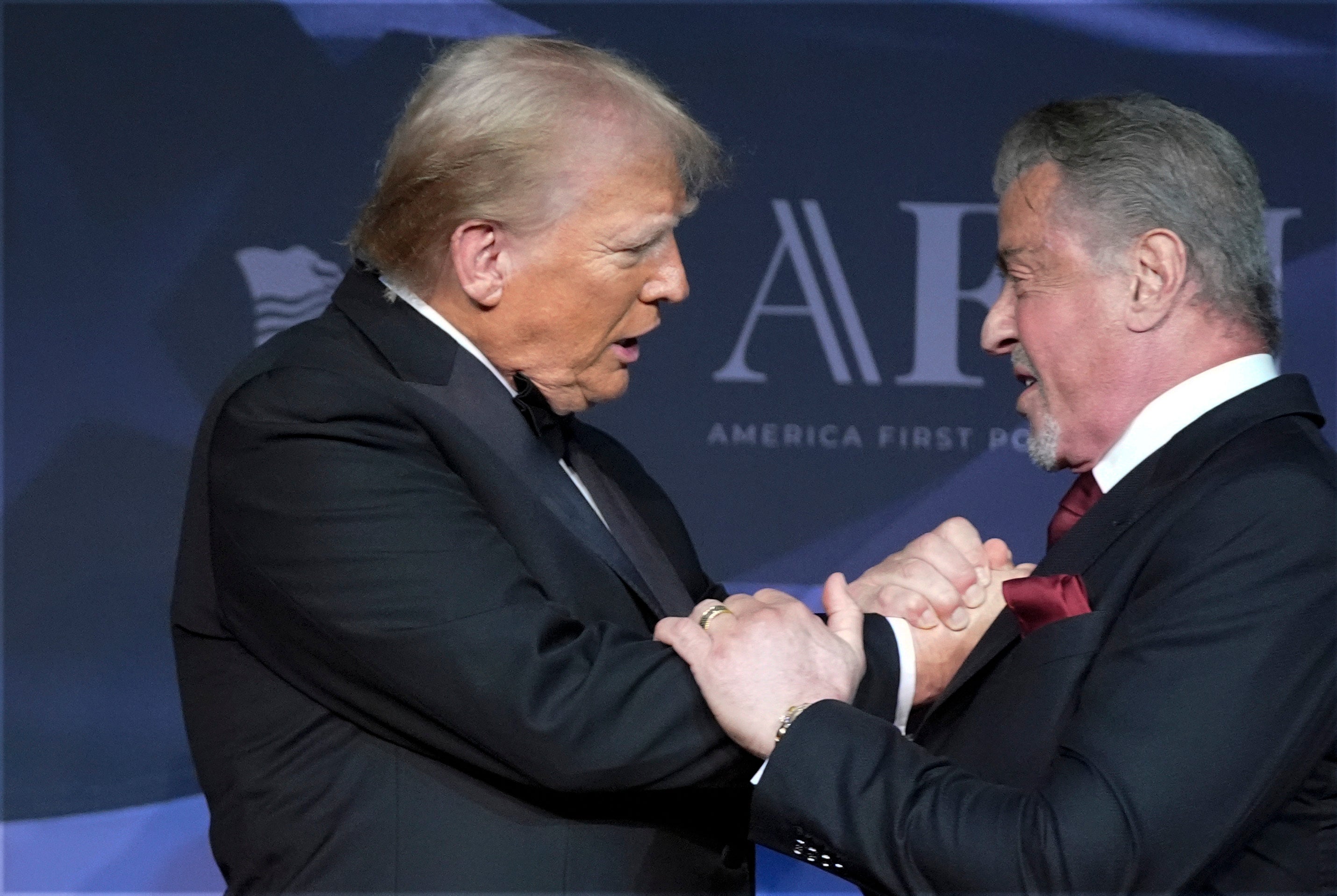 Donald Trump greets actor Sylvester Stallone at the America First Policy Institute gala