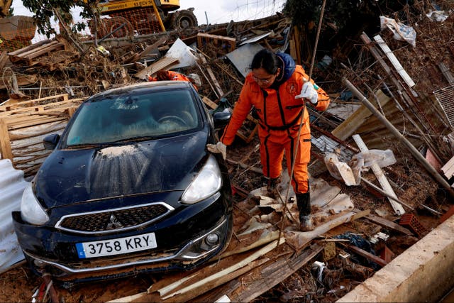 <p>Rescuers search for bodies in the Torre neighbourhood in Valencia</p>