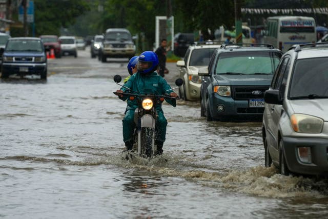 <p>A motorcyclist rides down a street flooded by rains from Tropical Storm Sara in La Lima, Honduras. The storm moved through the Caribbean and doused Honduras with rain on Friday. But, there were not yet signs of the serious flooding that is still expected. </p>