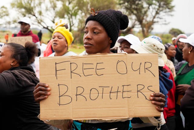 <p>Relatives and friends protest near a reformed gold mineshaft where illegal miners are trapped in Stilfontein</p>