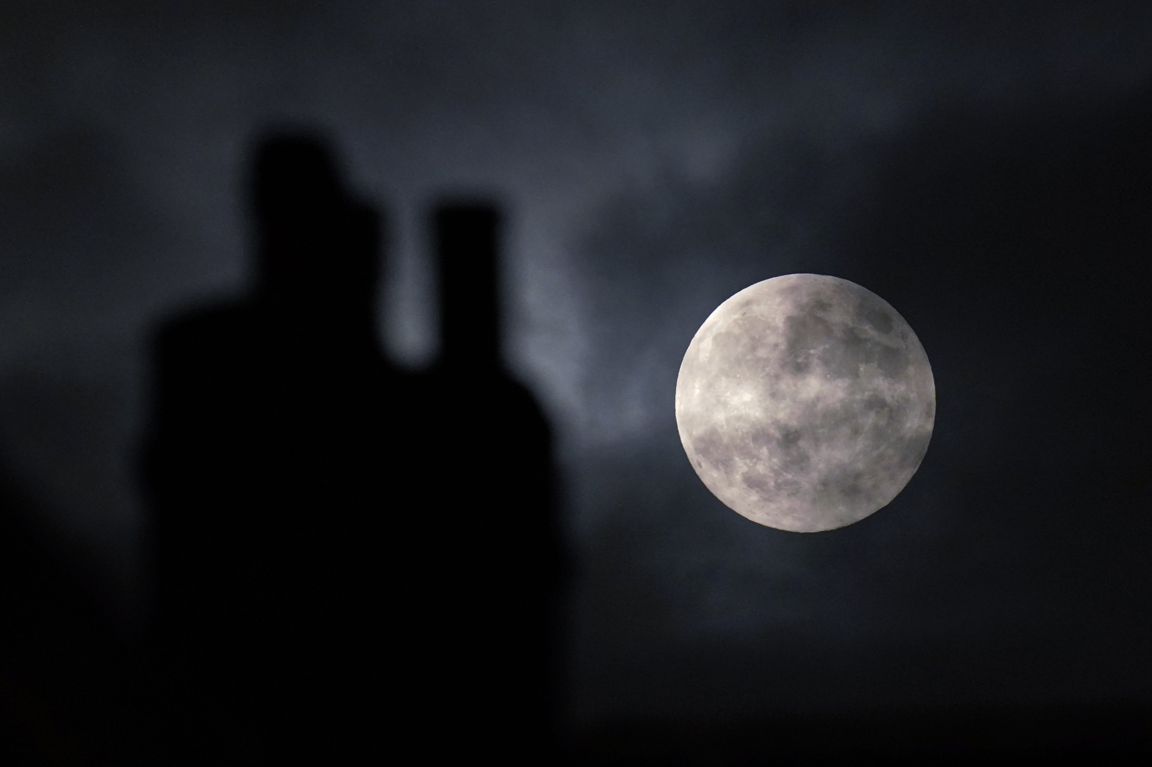 The supermoon is seen next to a chimney in central London on Friday