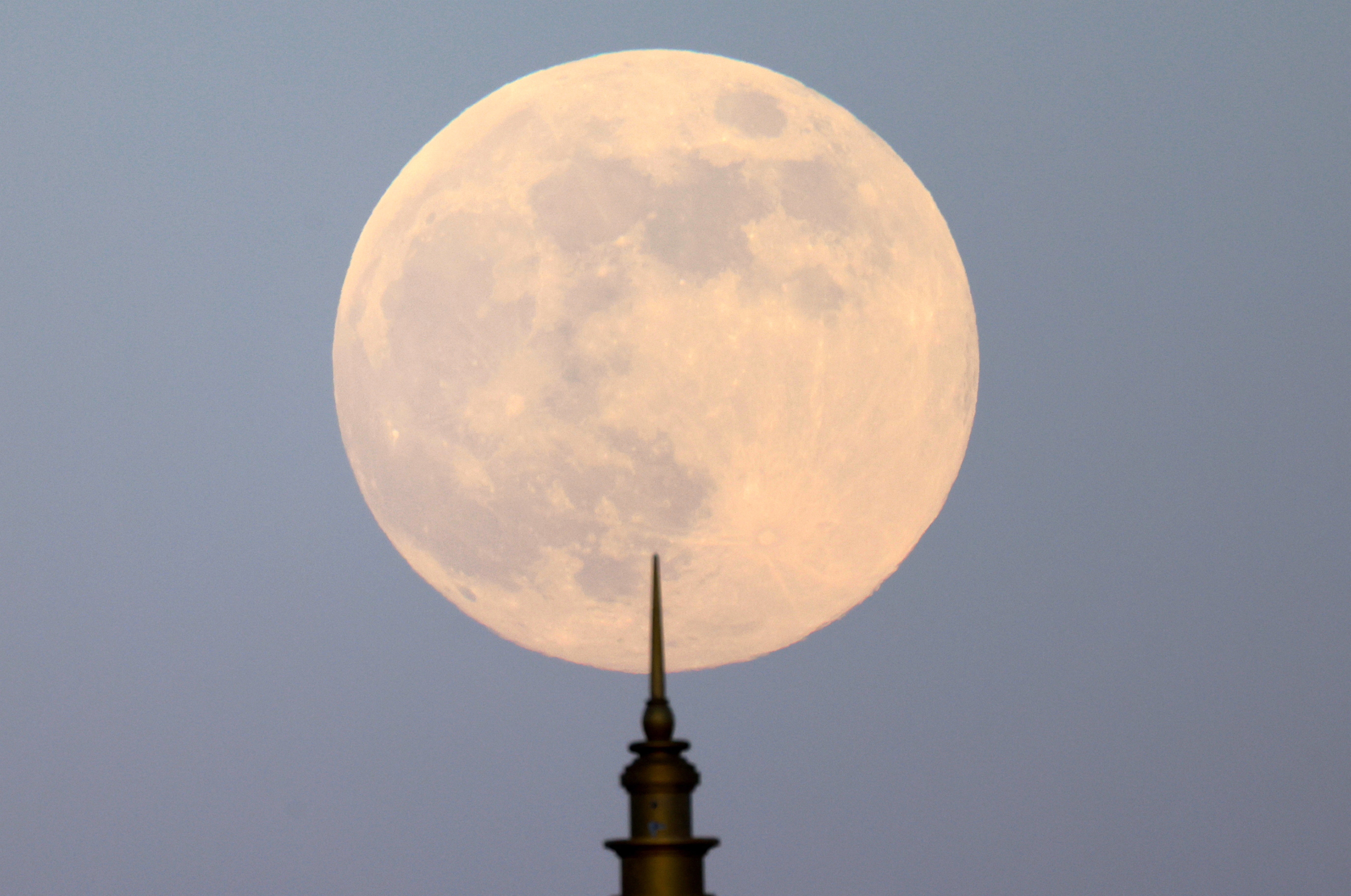 The last supermoon of 2024 rises behind a minaret of a mosque in Cairo, Egypt