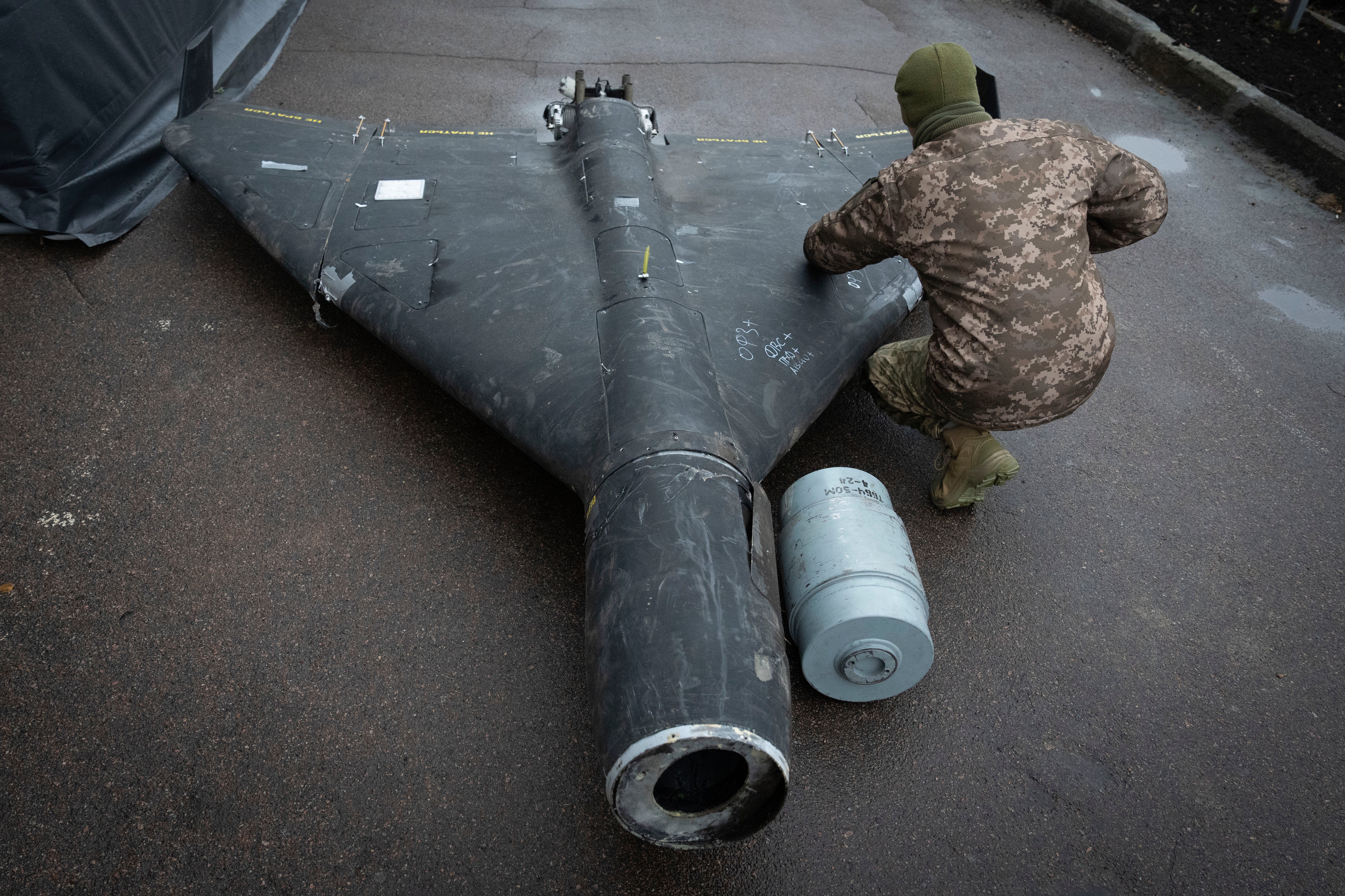 A Ukrainian officer examines a downed Shahed drone with a thermobaric charge launched by Russia