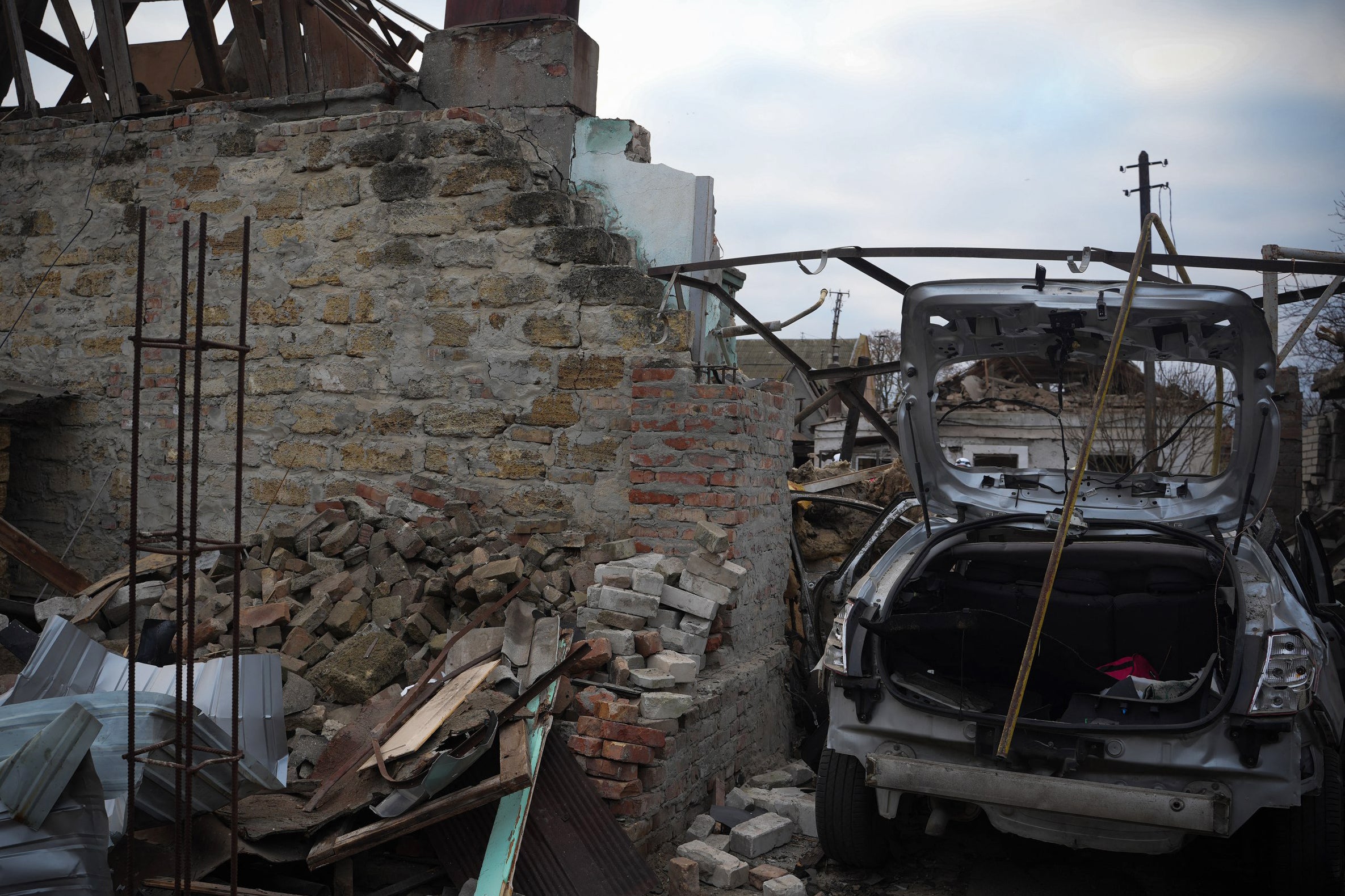 A car and buildings destroyed as a result of a drone attack in Mykolaiv on Sunday morning