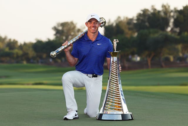 <p>Rory McIlroy poses with the DP World Tour Championship trophy (left) and the Race to Dubai trophy on the 18th green following victory at Jumeirah Golf Estates, Dubai</p>