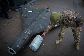 A Ukrainian officer shows a thermobaric charge of a downed Shahed drone launched by Russia in a research laboratory in an undisclosed location in Ukraine earlier in November