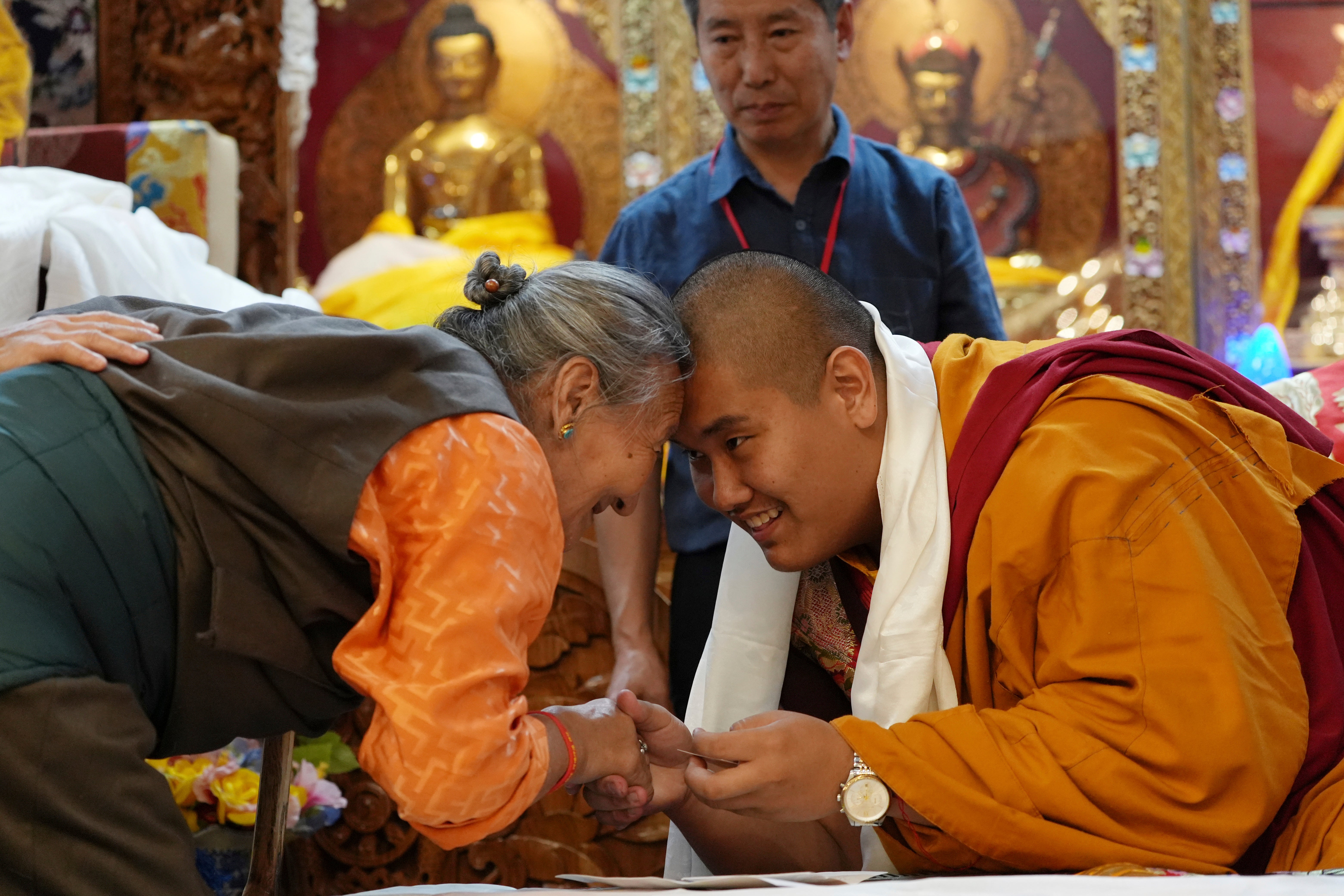 U.S.-born Buddhist lama, Jalue Dorje, right, and a member of the Minnesota Tibetan community bow and touch foreheads in a traditional Tibetan greeting at his 18th birthday and enthronement ceremony