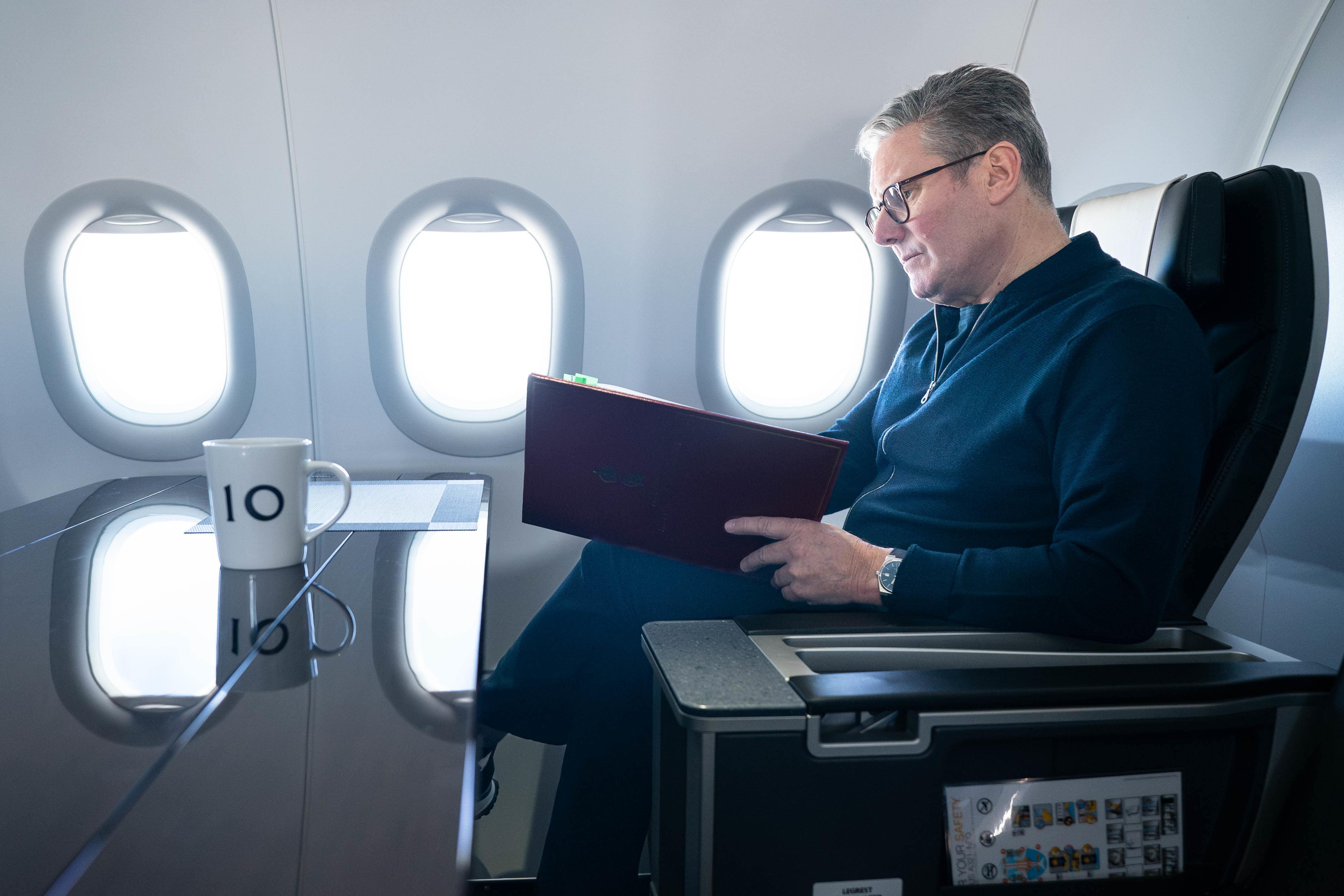 Prime Minister Sir Keir Starmer works on board a Government plane (Stefan Rousseau/PA)