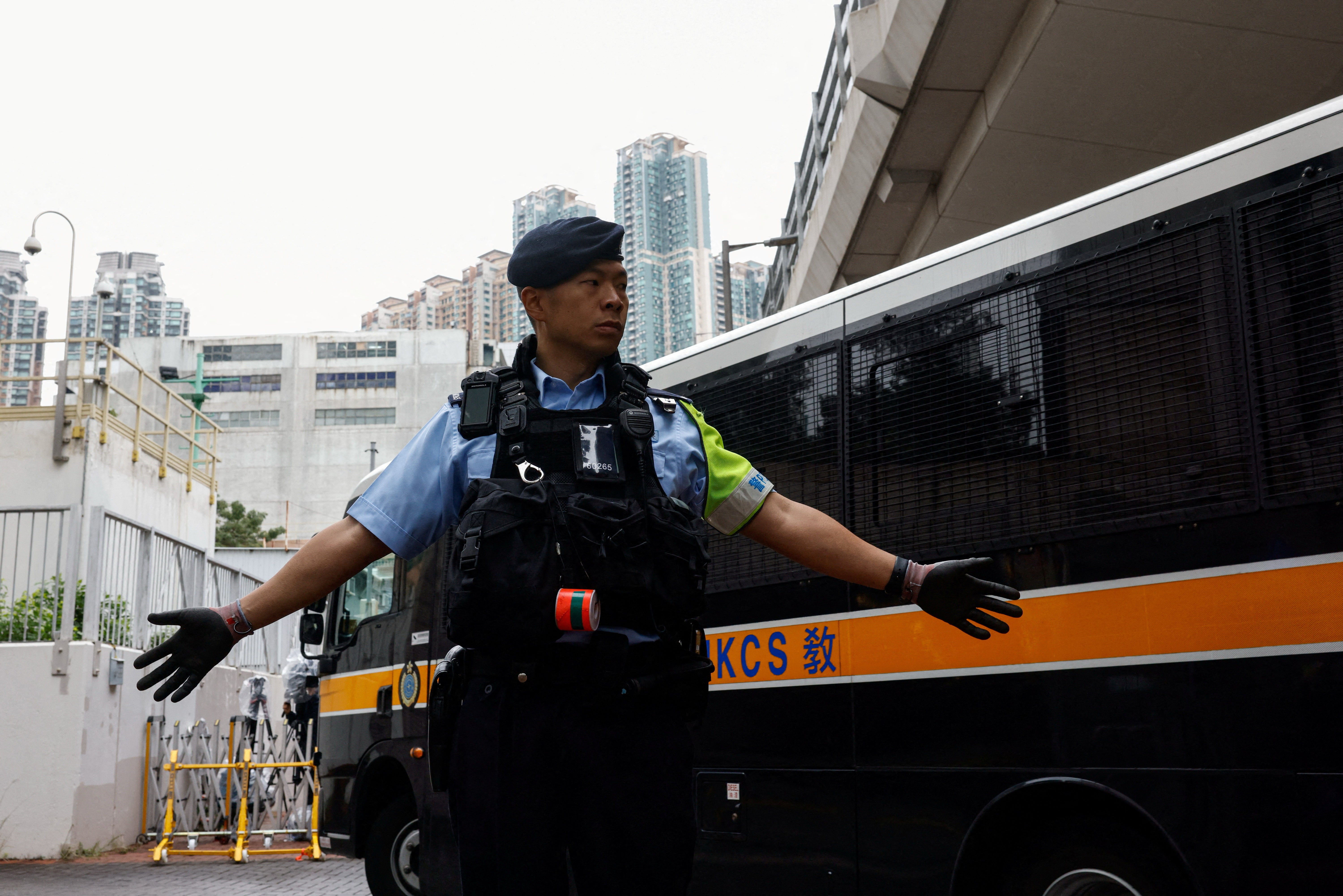 A police officer stands guard as a prison van arrives at the Hong Kong High Court ahead of sentencing in the national security case on 19 November 2024