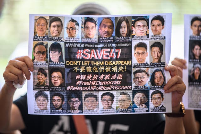 <p>File: A supporter holds a poster showing some of the 47 pro-democracy activists on trial at the West Kowloon Court in Hong Kong on 8 July 2021</p>